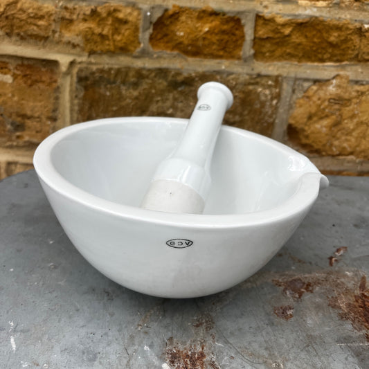 A large vintage GDV porcelain pestle and mortar with a classic white glazed finish and substantial, heavy design. The deep bowl features a pouring lip and sturdy rounded base, accompanied by a matching porcelain pestle