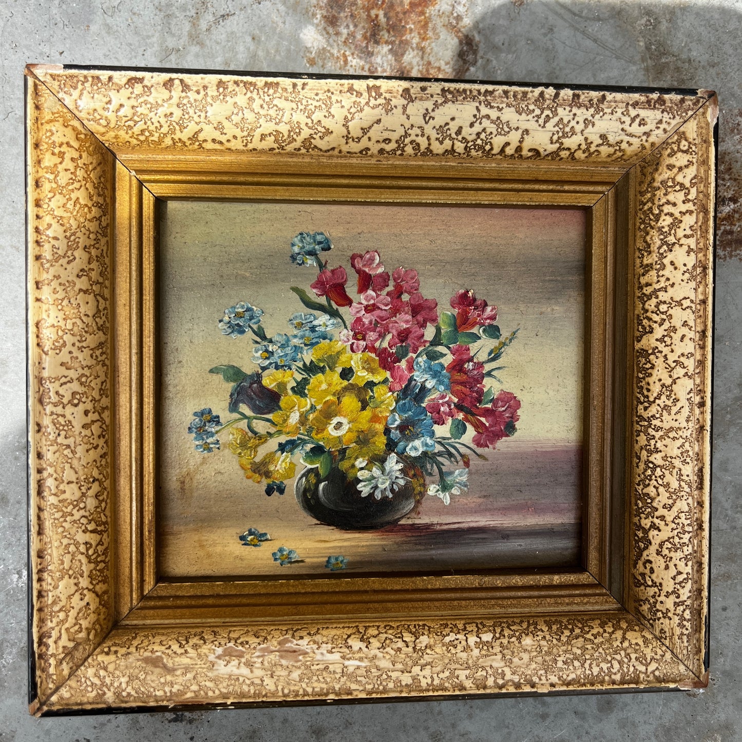 A framed vintage oil painting on canvas depicting a traditional floral still life, with an arrangement of flowers in a decorative vase.  In a decorative frame.