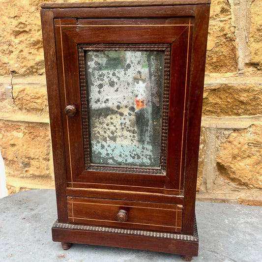 French vintage miniature wardrobe with a panelled mirrored door which has a lovely foxed effect. The small-scale piece features delicate detailing and evokes the charm of classic French country furniture.