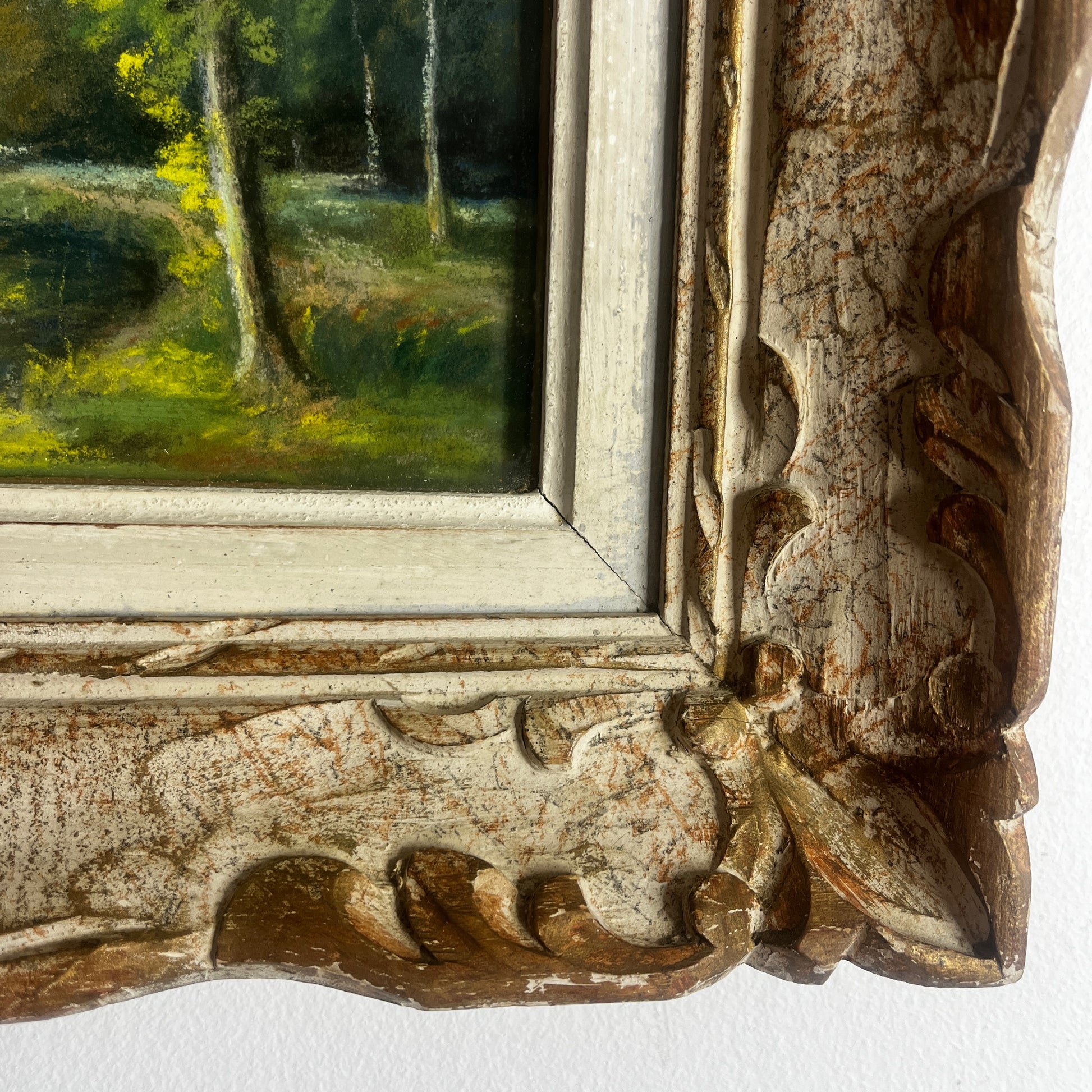 A vintage oil painting of a tranquil wooded landscape featuring a calm river or lake reflecting the sky, with trees lining the water and a small building nestled among the trees in the distance.  Montparnasse Frame.