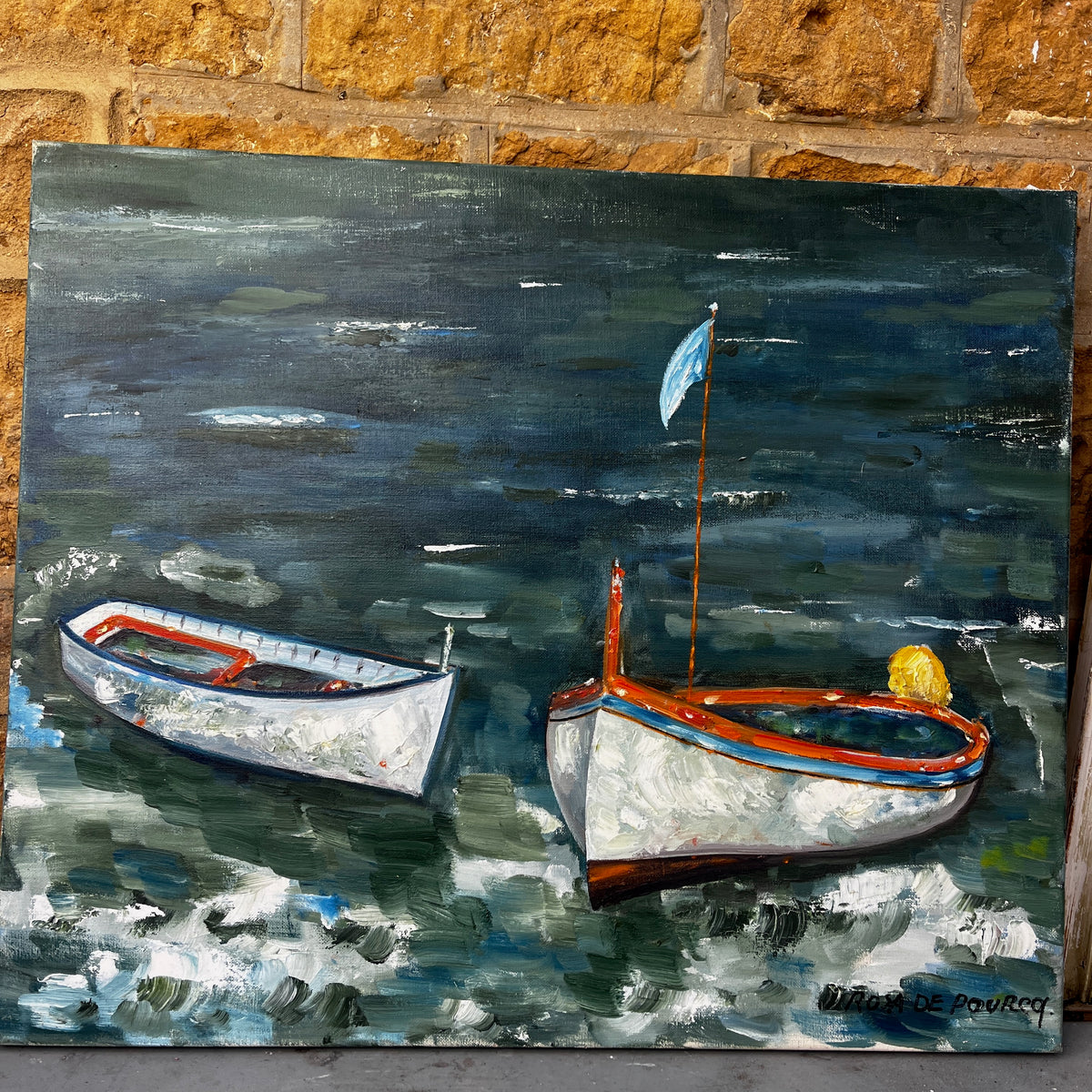 An oil painting of two small boats on dark, textured water. The painting features expressive brushstrokes in navy, green, white, and orange-red, with a signature in the bottom right corner.