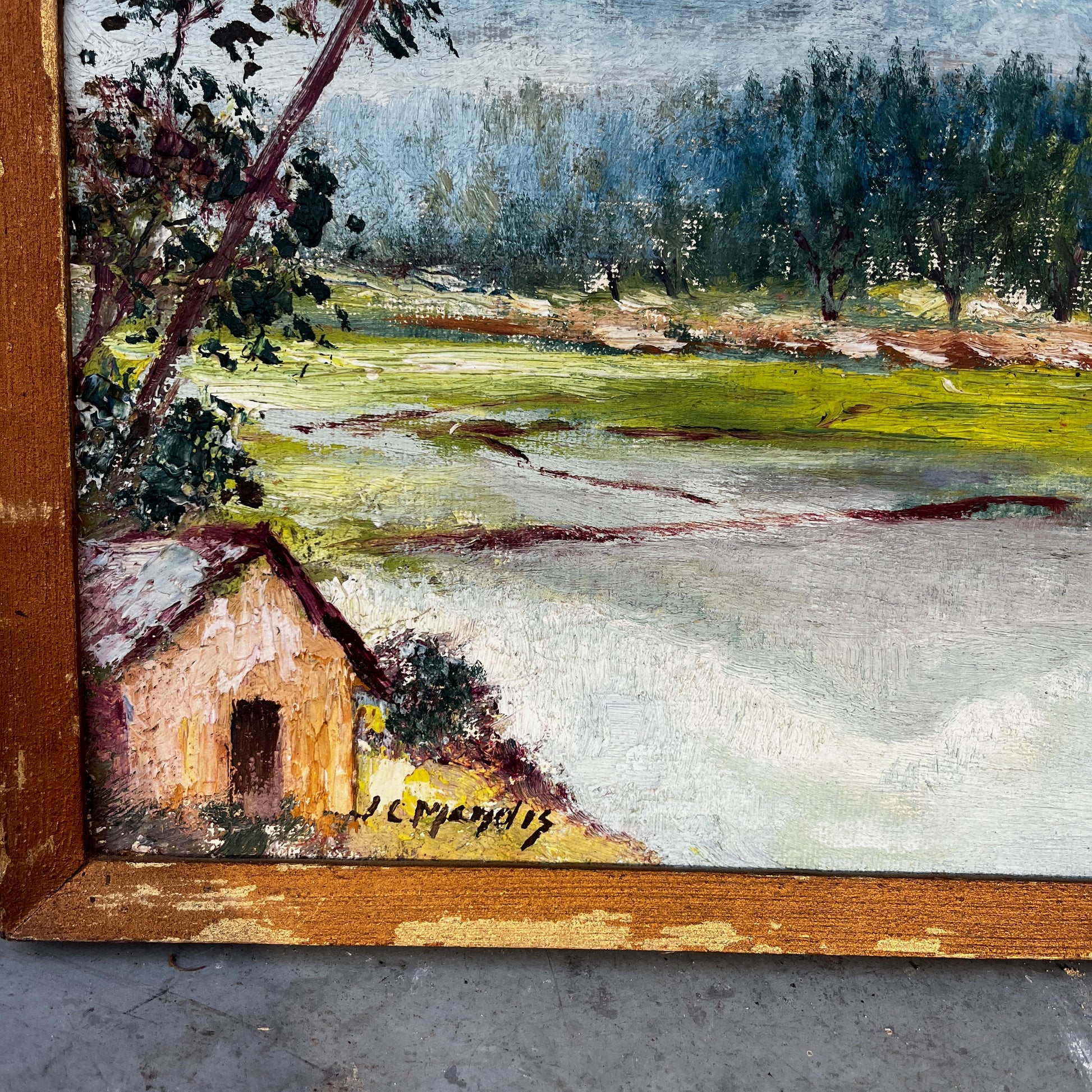 Framed vintage oil on board painting of a mountain lake scene, depicting tranquil water surrounded by rugged peaks and soft atmospheric light.