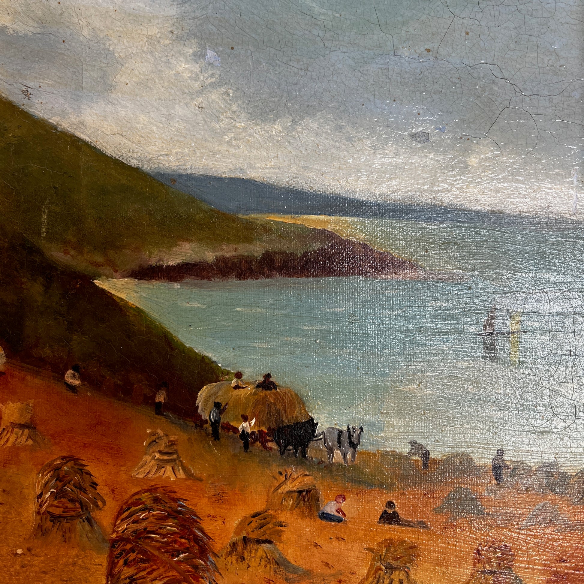 A vintage oil painting on canvas depicting a tranquil coastal scene with blue water, a sandy shoreline, and distant cliffs or headland beneath a softly painted sky. The atmospheric landscape is presented in an ornate gold-coloured frame, adding a classic, elegant touch to the artwork