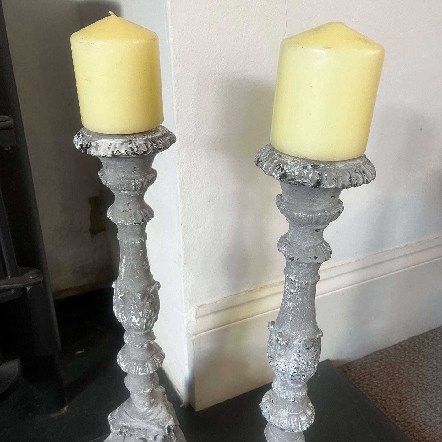 A pair of vintage French decorative candle holders with an elegant distressed finish and ornate detailing