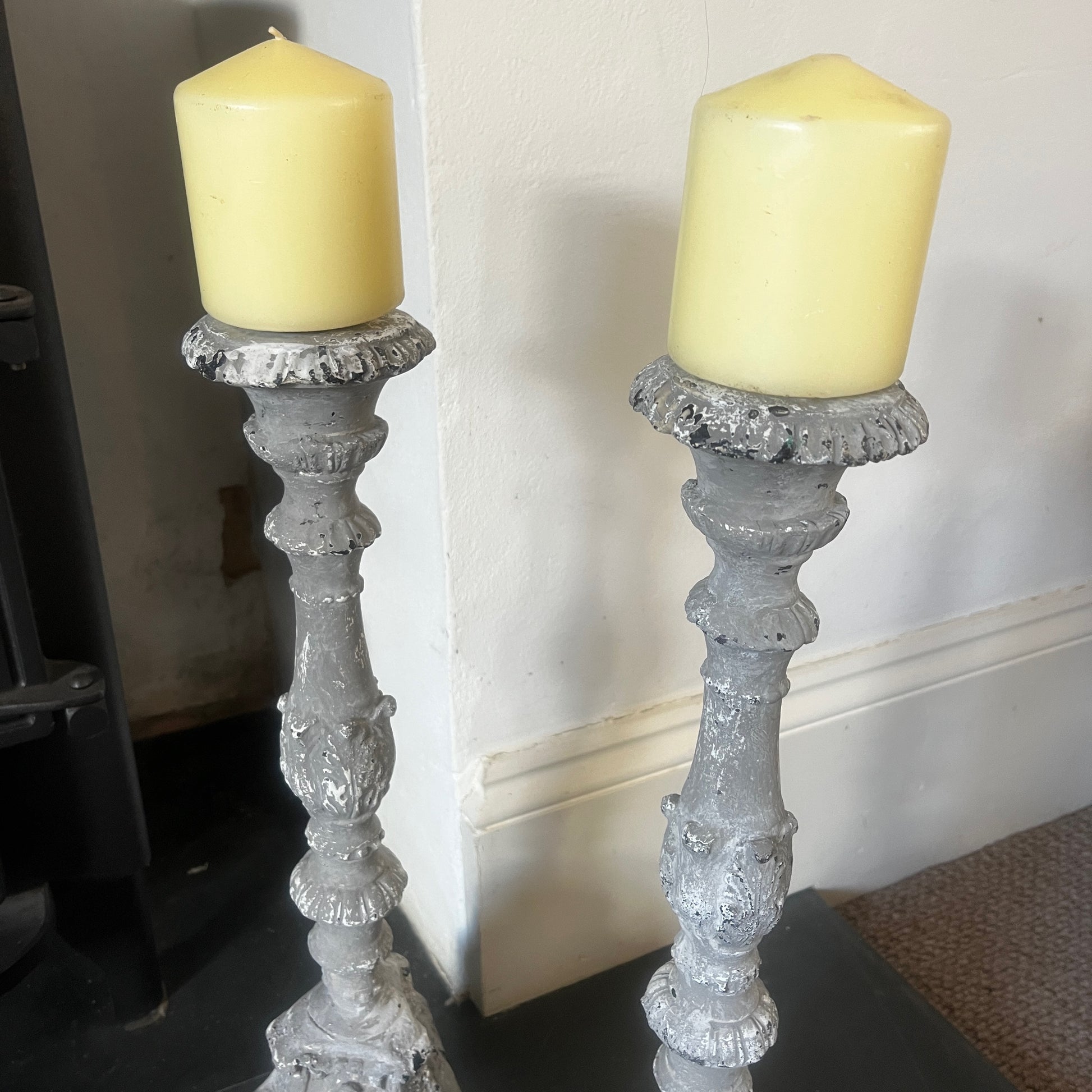 A pair of vintage French decorative candle holders with an elegant distressed finish and ornate detailing