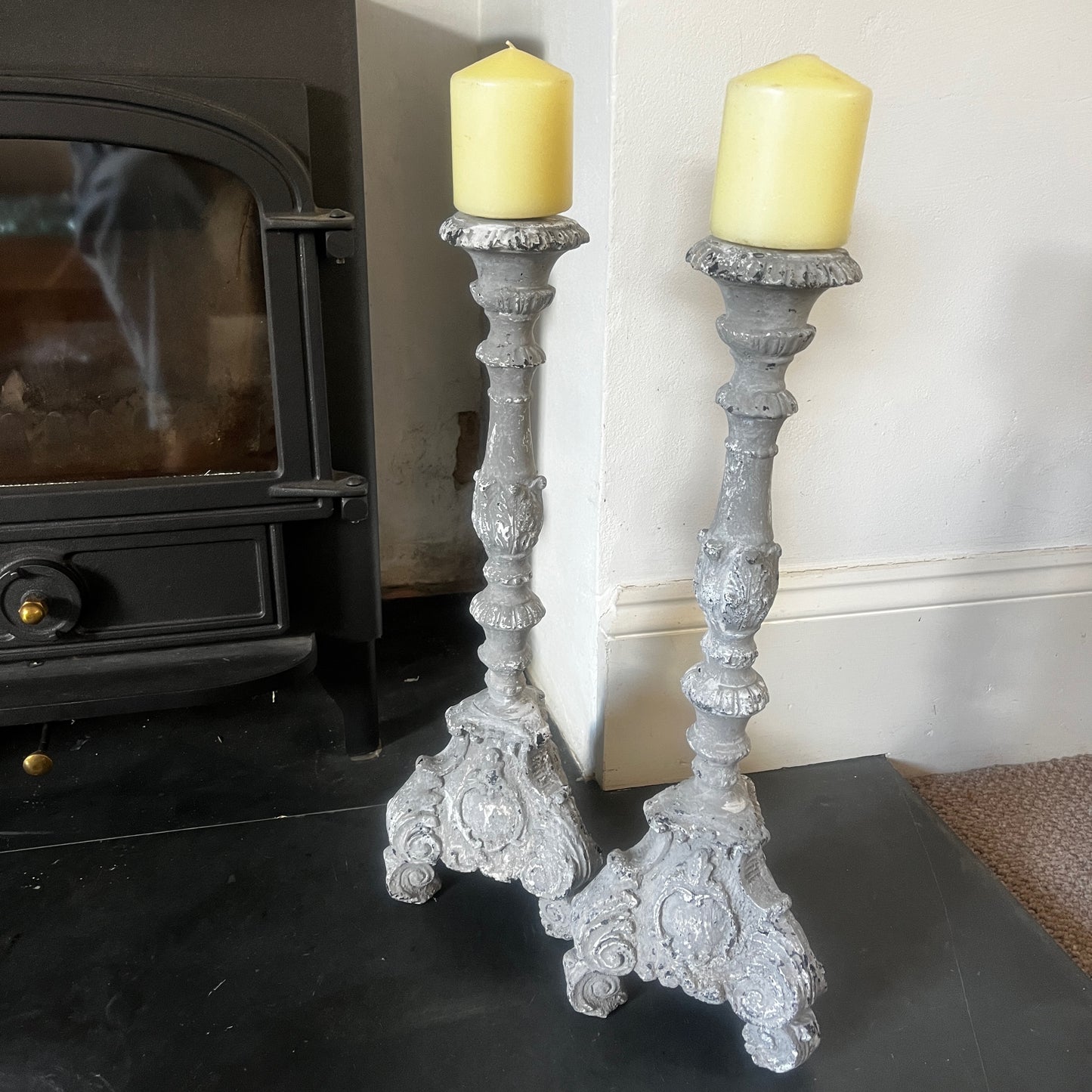 A pair of vintage French decorative candle holders with an elegant distressed finish and ornate detailing