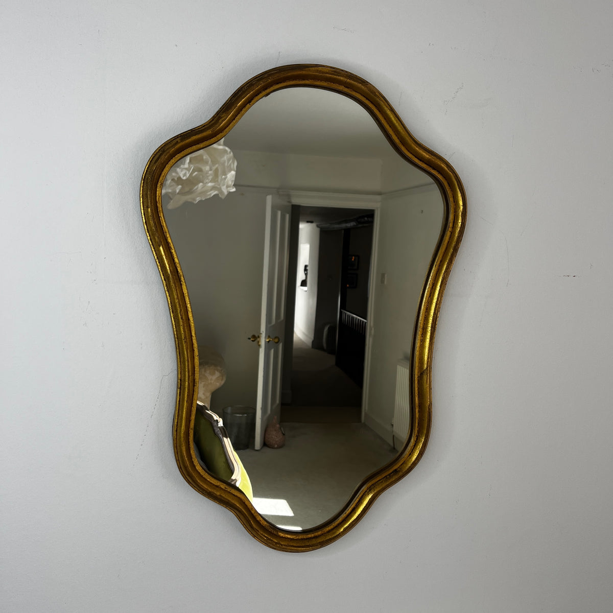 Vintage French Rococo-style wall mirror with an ornate giltwood frame and decorative carved detailing