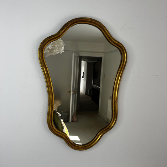 Vintage French Rococo-style wall mirror with an ornate giltwood frame and decorative carved detailing
