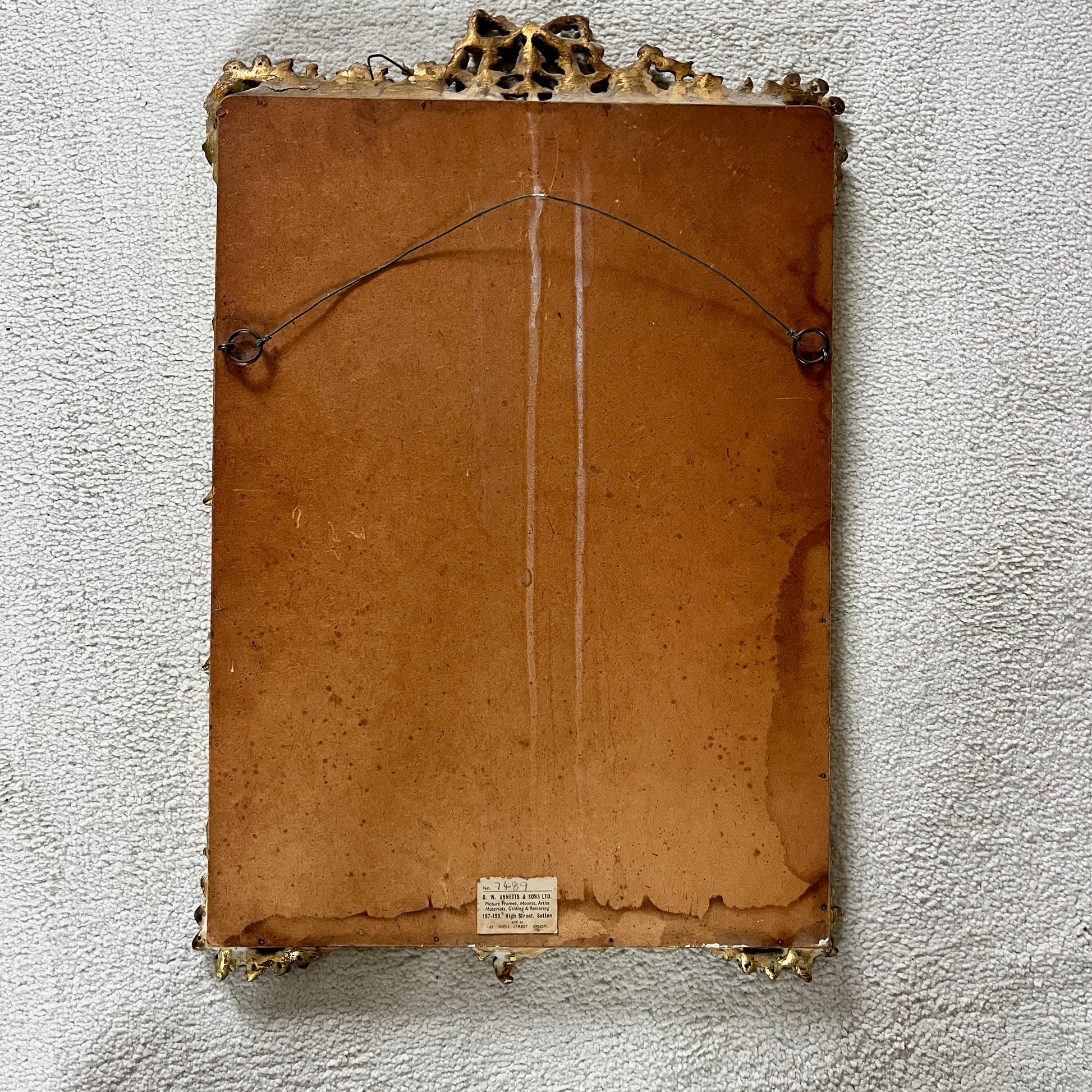 A vintage Rococo-style gilded beveled mirror with an ornate, intricately carved frame featuring scrolling foliage, shells, and asymmetrical rocaille motifs, finished in a rich gold leaf patina.