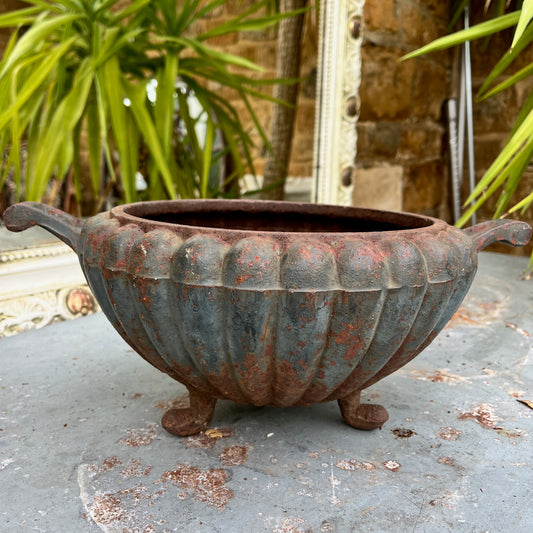 A round French jardinière crafted from metal.  The planter has a classic, slightly weathered finish, with subtle decorative accents, exuding rustic French elegance