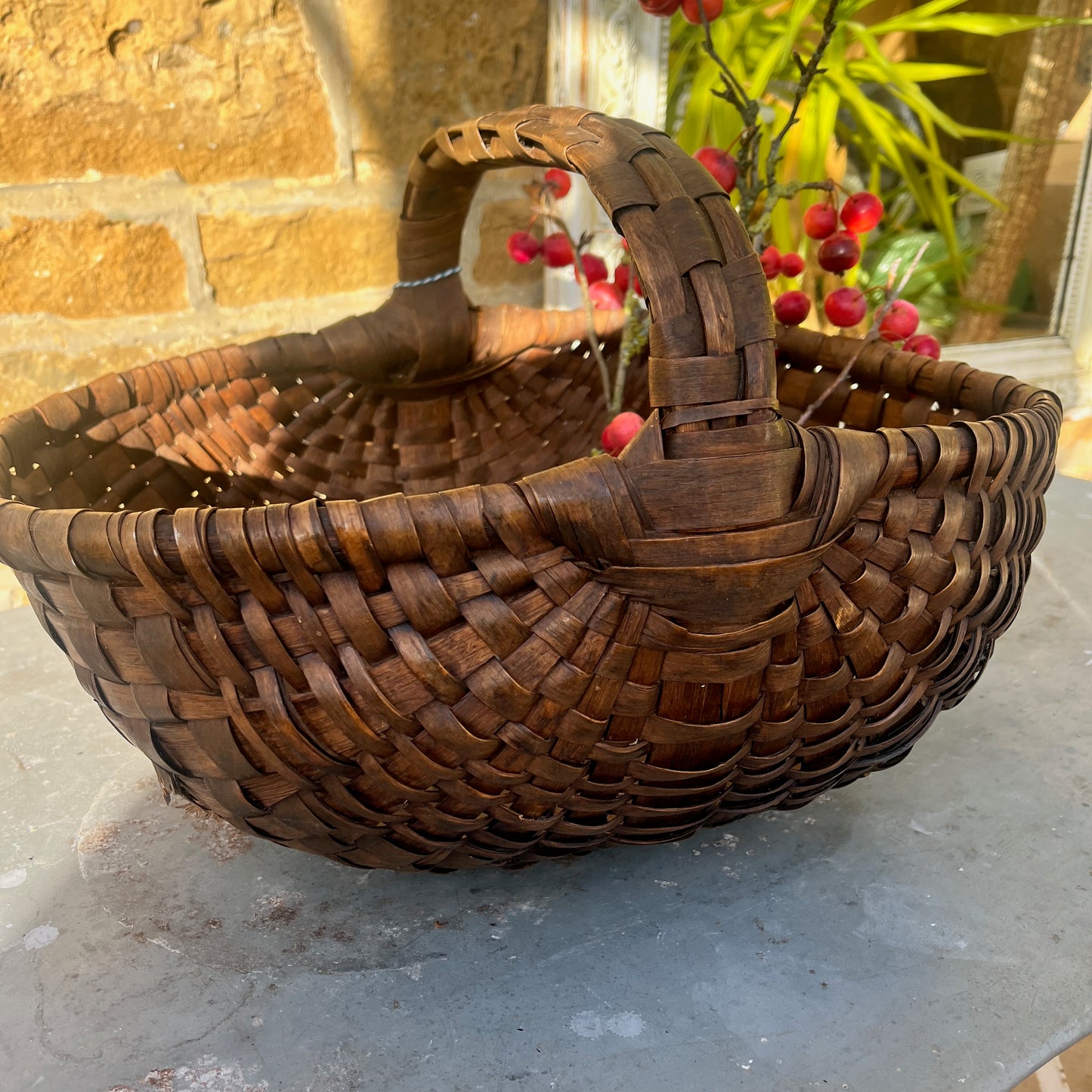 Large rush basket woven from natural fibers with a sturdy, rounded form. The basket has a rustic, handcrafted appearance, showcasing traditional weaving techniques and a textured, organic finish.