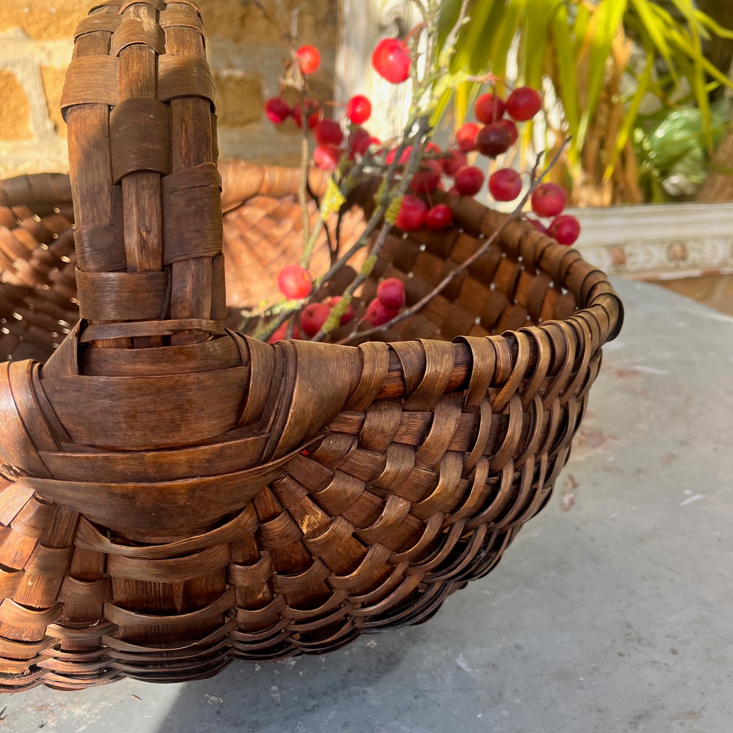 Large rush basket woven from natural fibers with a sturdy, rounded form. The basket has a rustic, handcrafted appearance, showcasing traditional weaving techniques and a textured, organic finish.