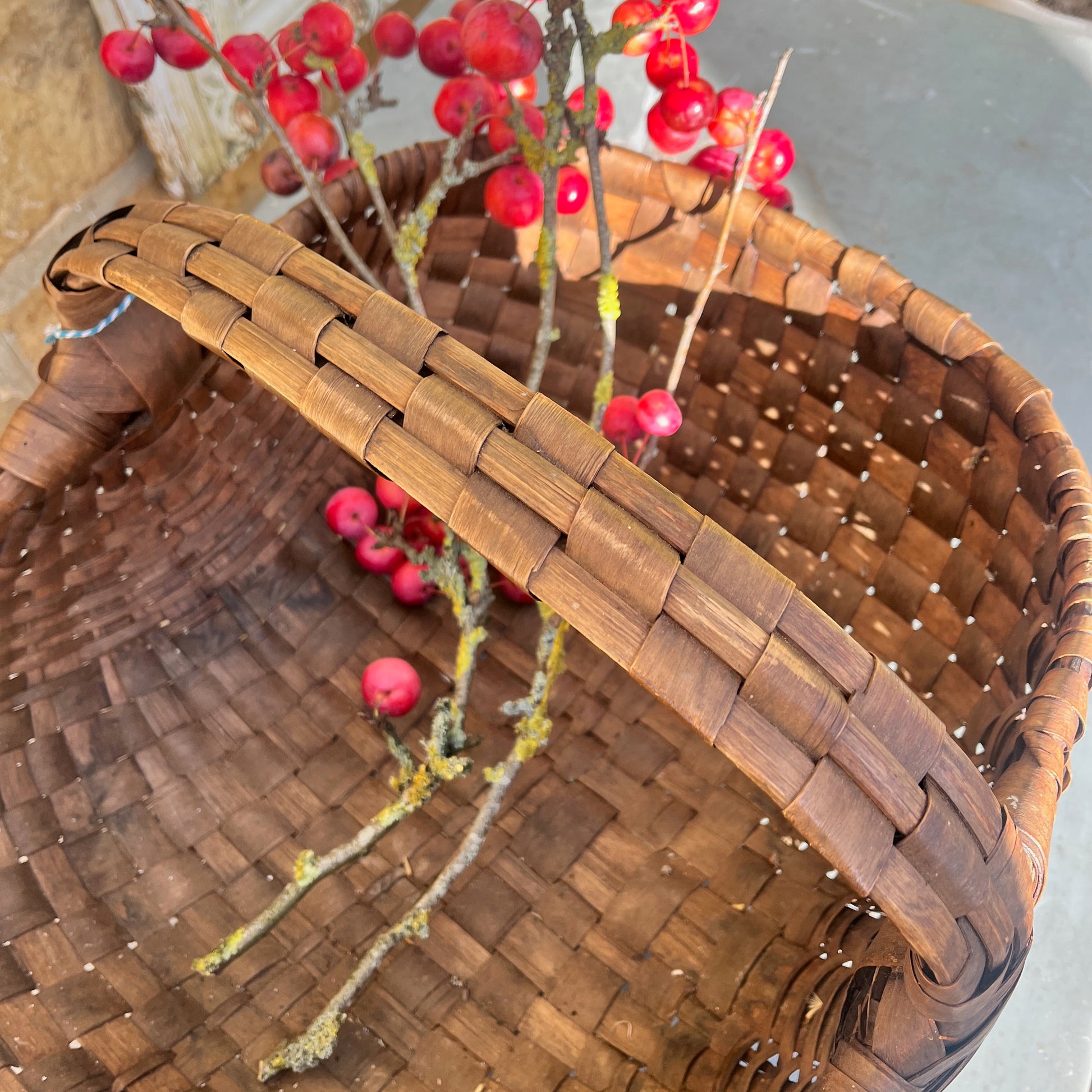Large rush basket woven from natural fibers with a sturdy, rounded form. The basket has a rustic, handcrafted appearance, showcasing traditional weaving techniques and a textured, organic finish.