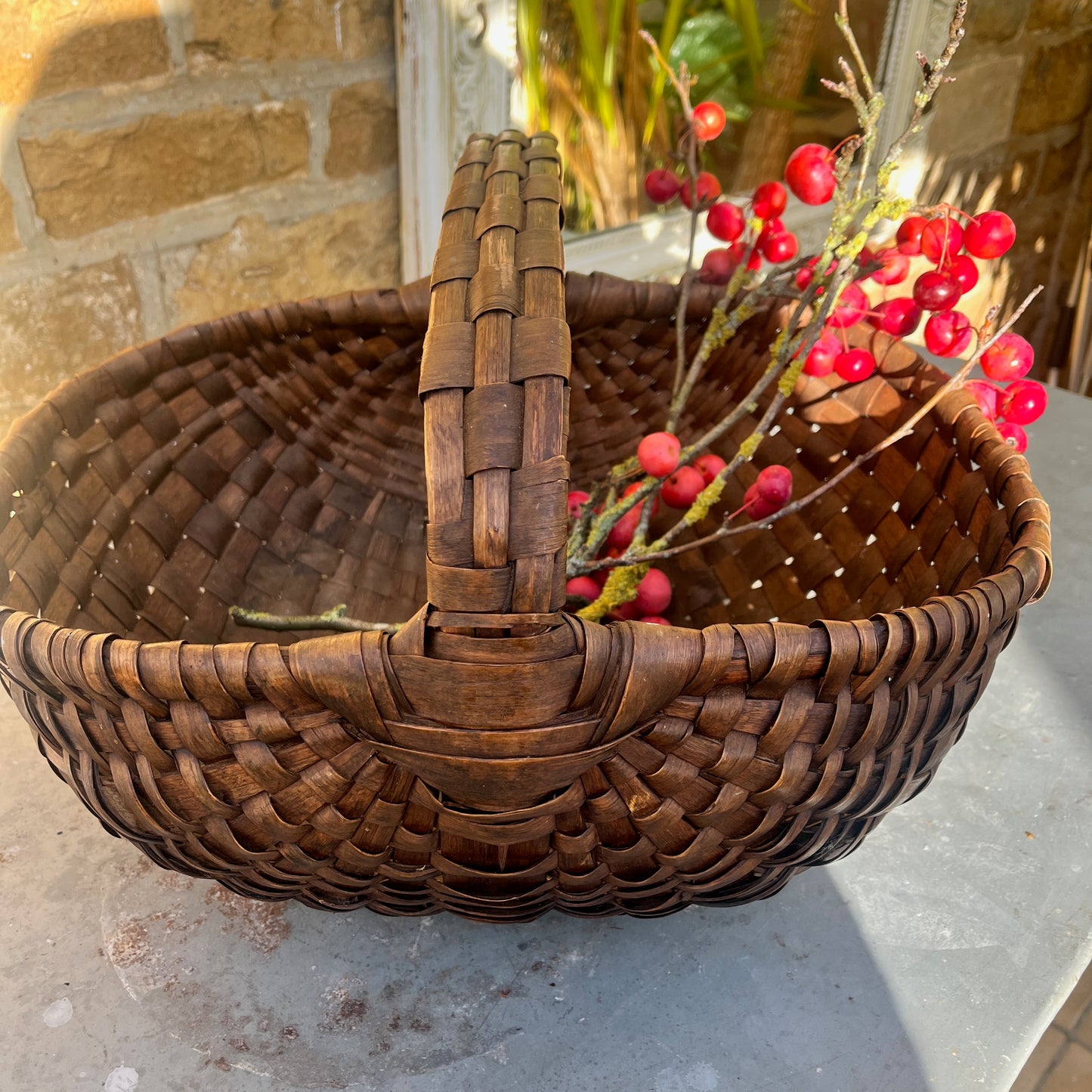 Large rush basket woven from natural fibers with a sturdy, rounded form. The basket has a rustic, handcrafted appearance, showcasing traditional weaving techniques and a textured, organic finish.