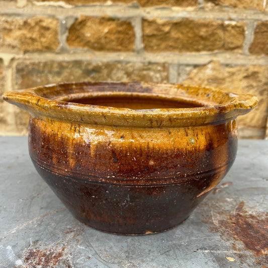 Vintage rustic ceramic pot in brown and ochre tones, featuring a simple handcrafted form and an earthy glazed finish with aged character.
