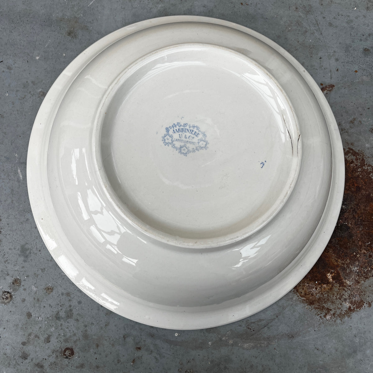 A blue and white ceramic pitcher with a floral pattern, placed inside a matching deep bowl.