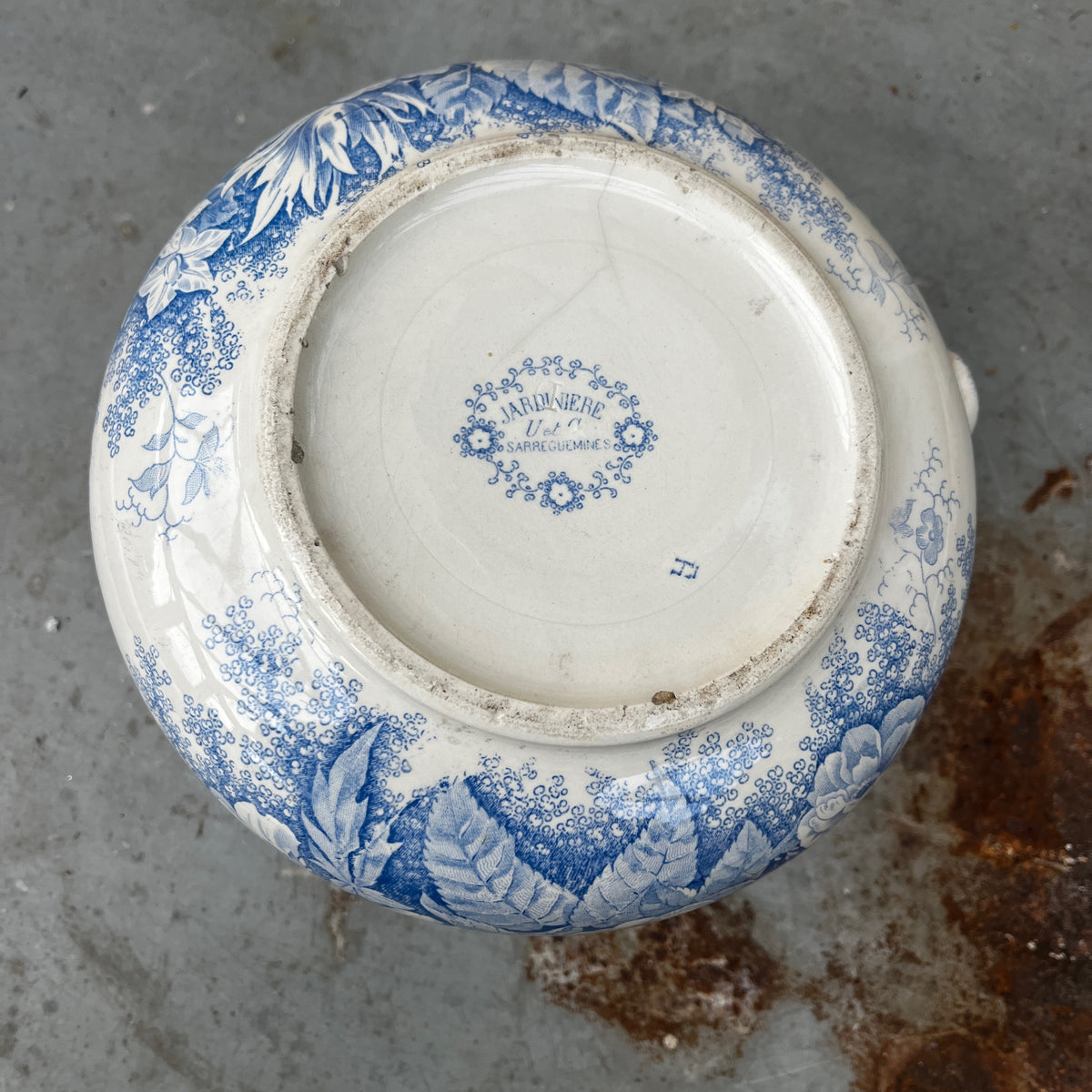 A blue and white ceramic pitcher with a floral pattern, placed inside a matching deep bowl.