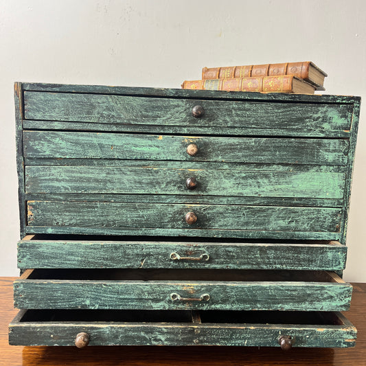 A vintage blue draftsman's box featuring multiple drawers for storage