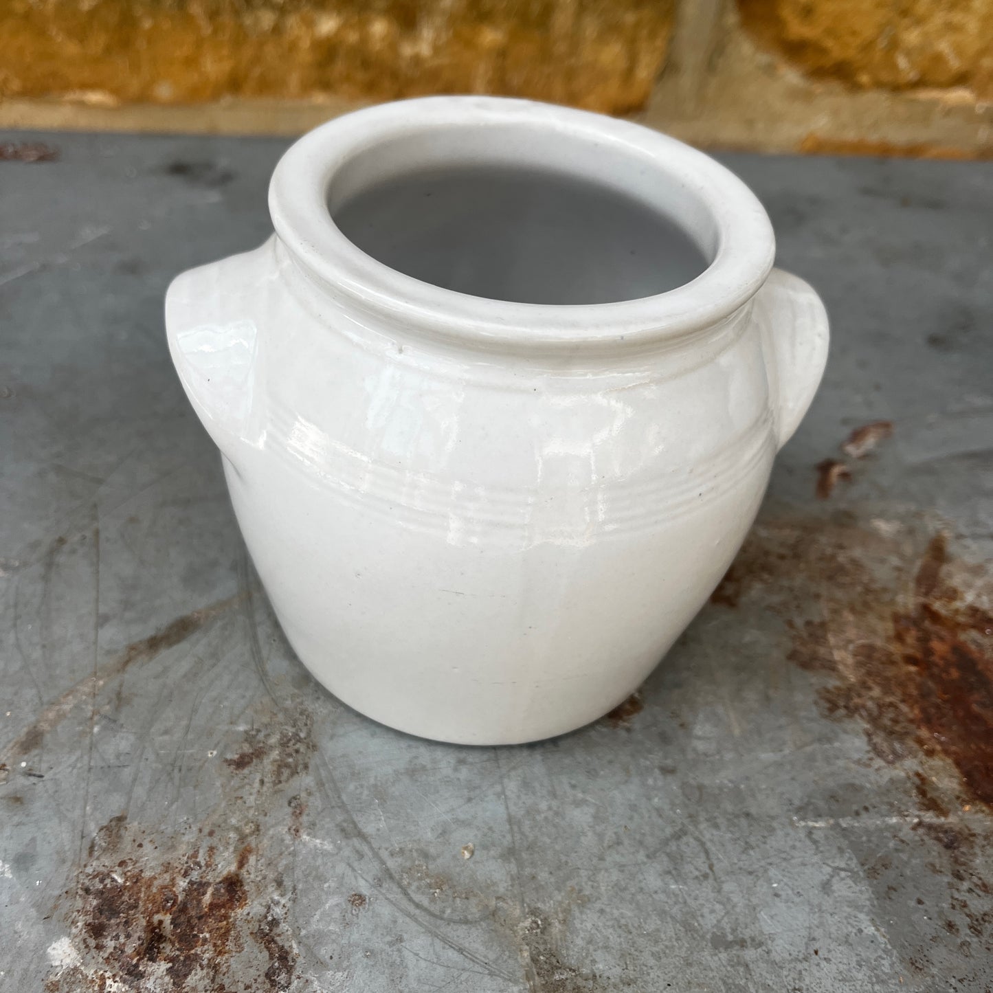 A small vintage white confit pot with a classic rounded shape and a beautifully aged glazed finish.