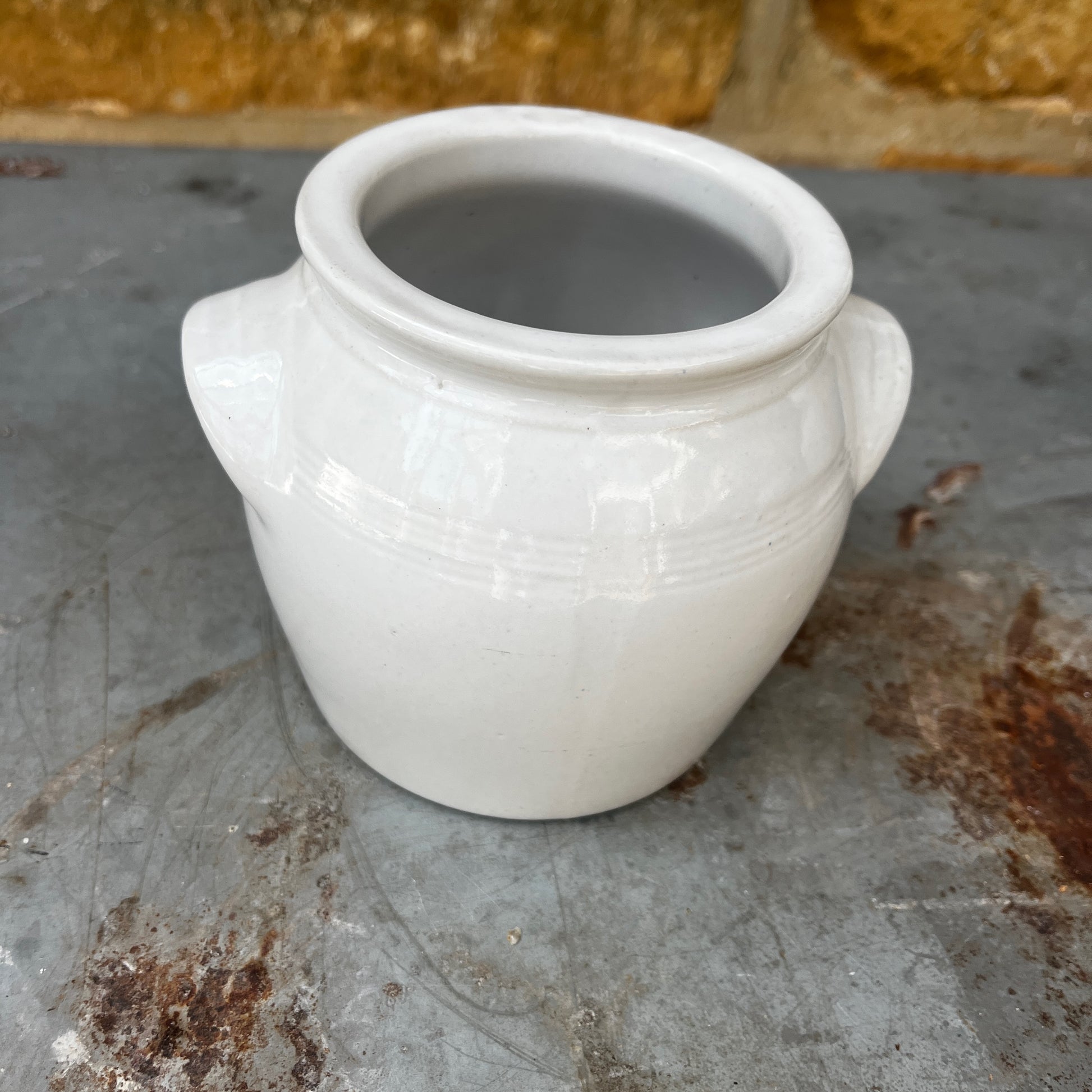 A small vintage white confit pot with a classic rounded shape and a beautifully aged glazed finish.