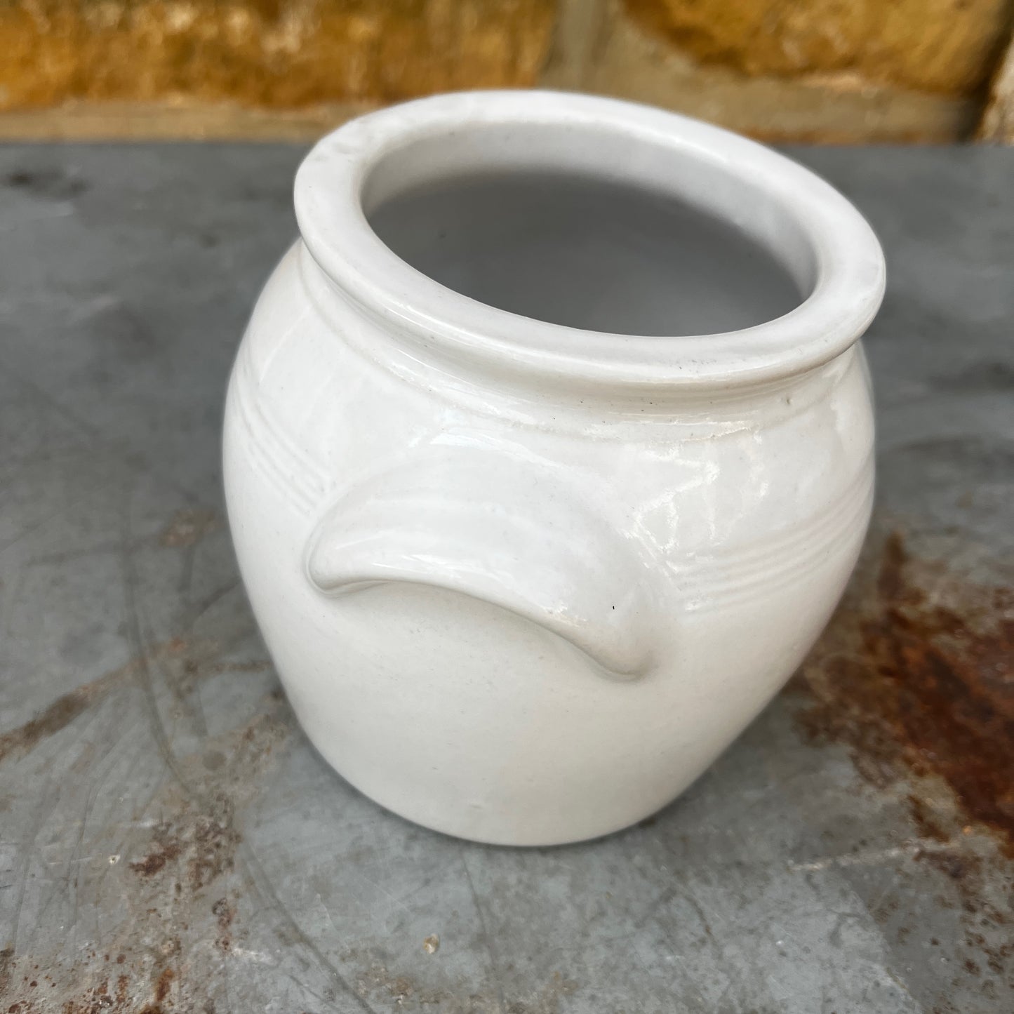 A small vintage white confit pot with a classic rounded shape and a beautifully aged glazed finish.