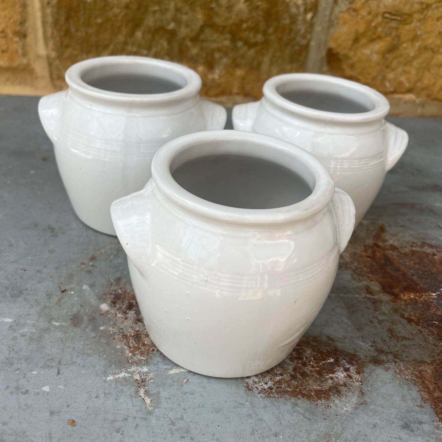 A small vintage white confit pot with a classic rounded shape and a beautifully aged glazed finish.