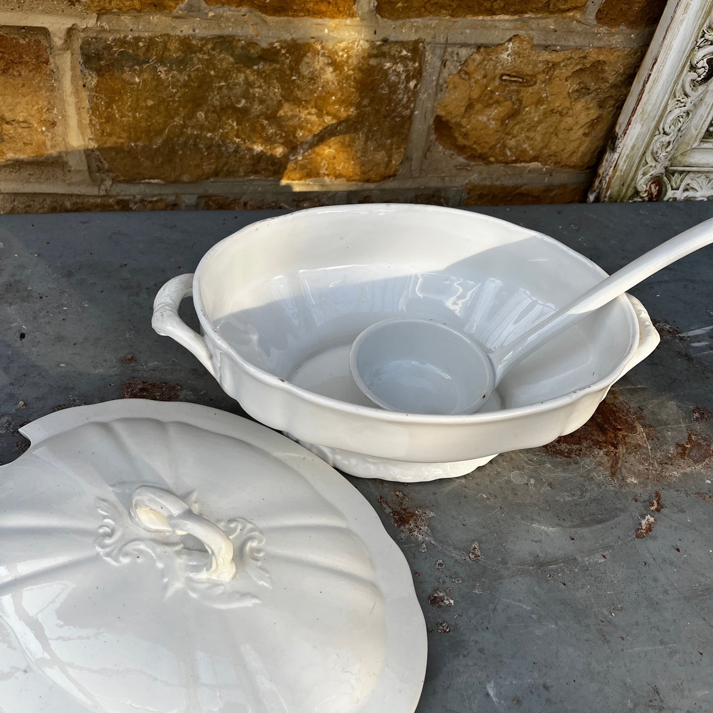 Vintage Belgian soup tureen with lid and matching ladle, featuring unusual white ceramic design and a traditional glazed finish.