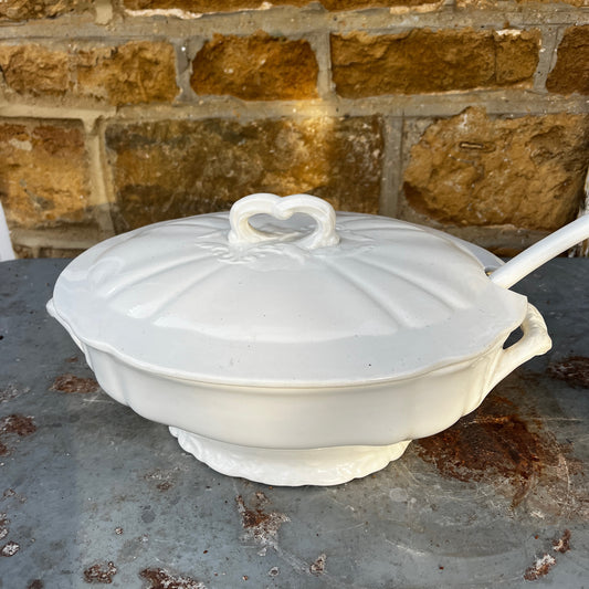 Vintage Belgian soup tureen with lid and matching ladle, featuring unusual white ceramic design and a traditional glazed finish.
