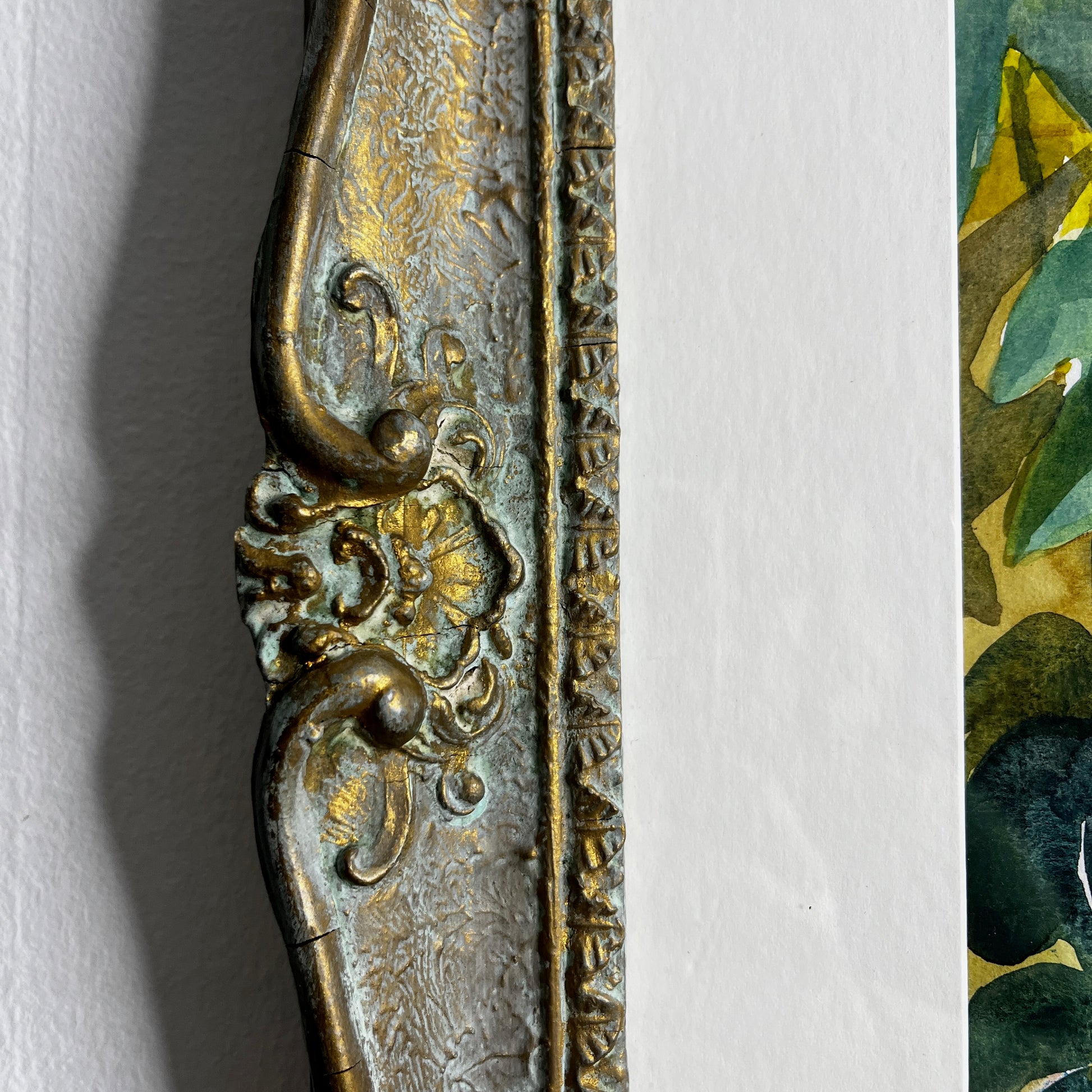 Still-life watercolor painting displayed in a vintage wooden frame, featuring softly rendered objects with delicate brushstrokes and muted, traditional colors.