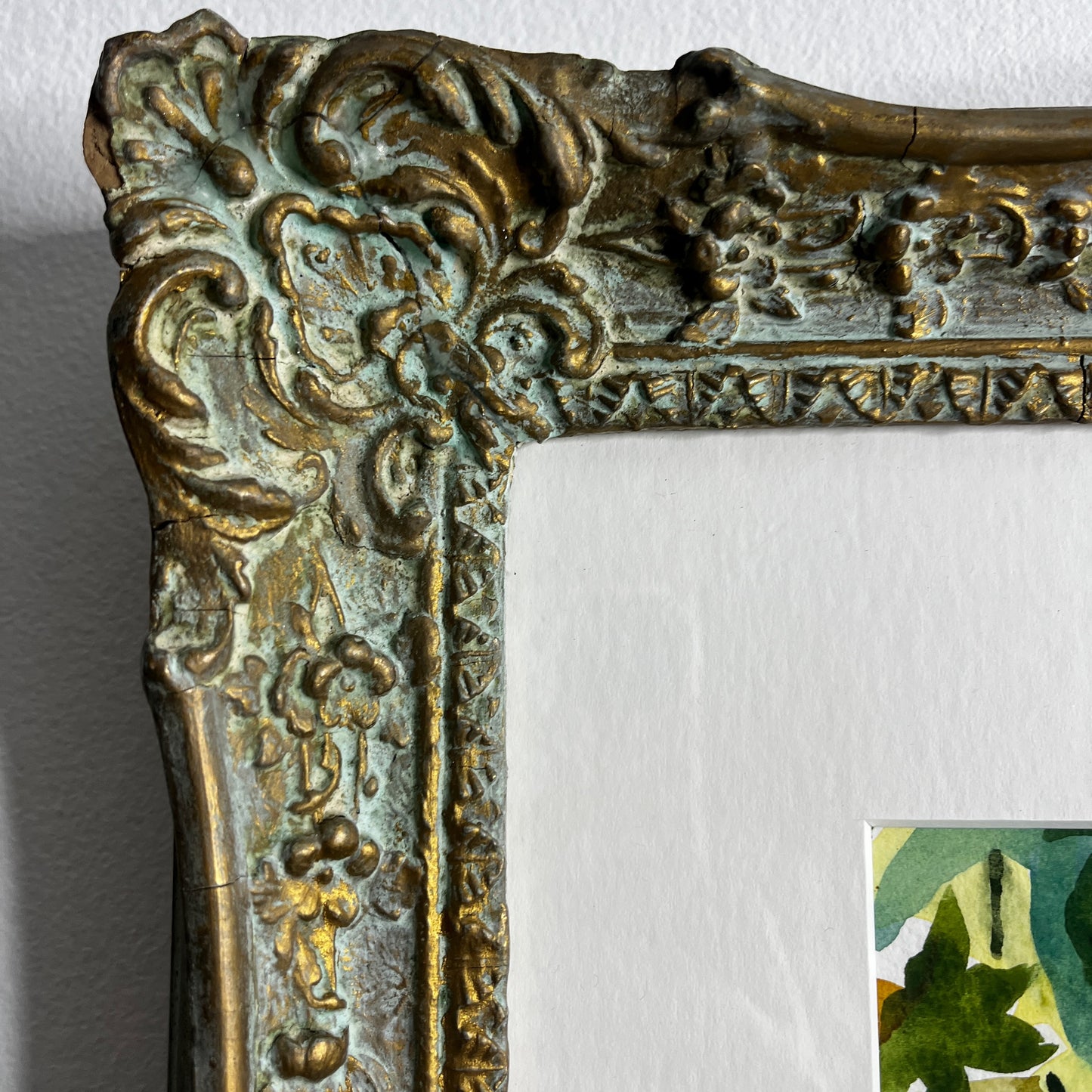 Still-life watercolor painting displayed in a vintage wooden frame, featuring softly rendered objects with delicate brushstrokes and muted, traditional colors.