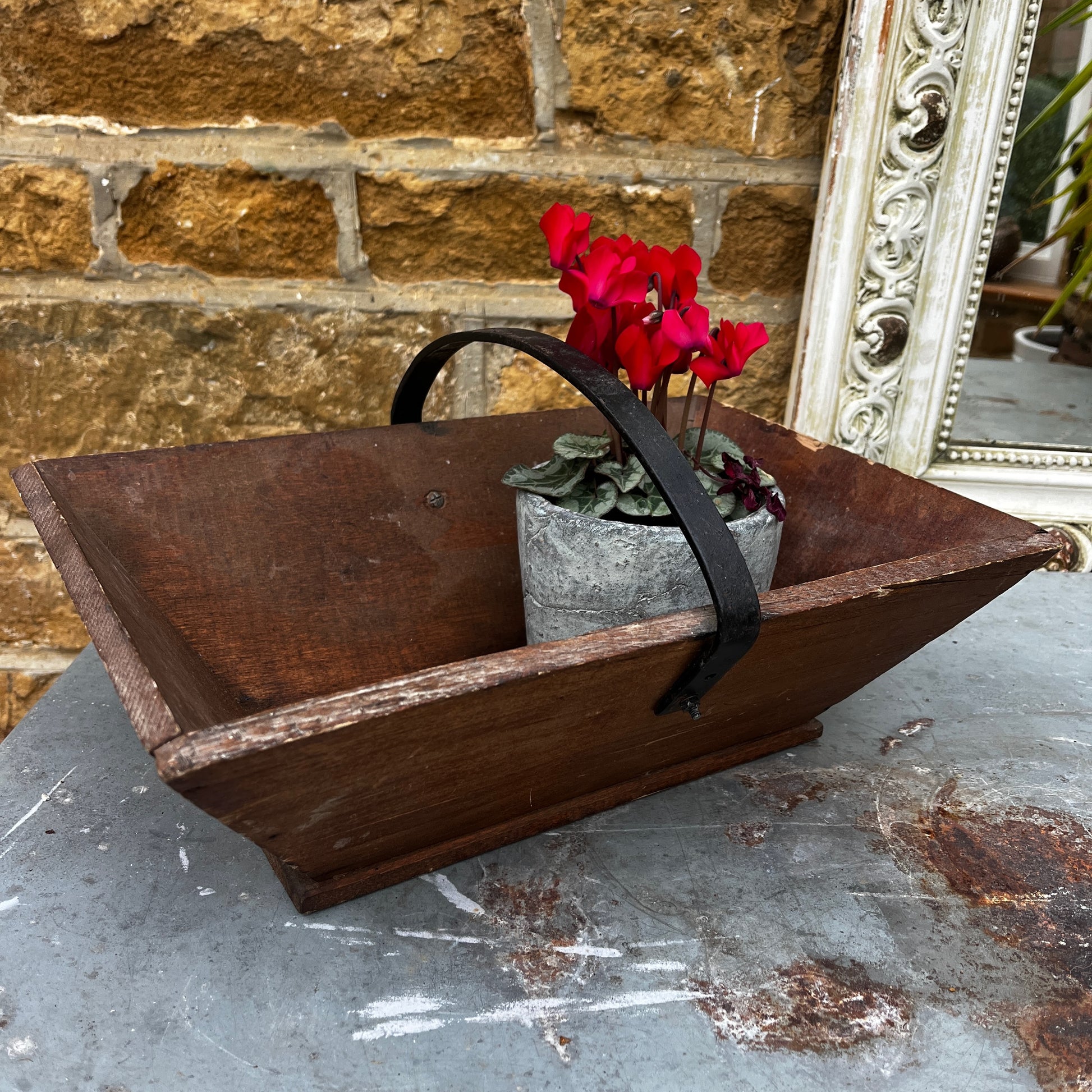 Rustic wooden trug with a black metal handle.