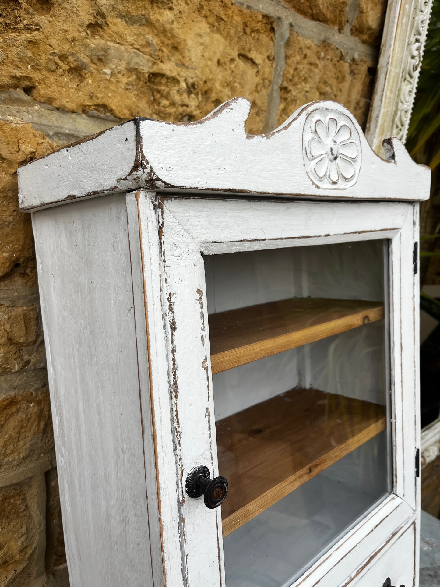 A French wall cupboard with a glazed glass door, two interior shelves, a single drawer, and practical hooks beneath. Its compact proportions and timeless rustic character make it ideal for use as a kitchen, bathroom, or hallway cabinet.