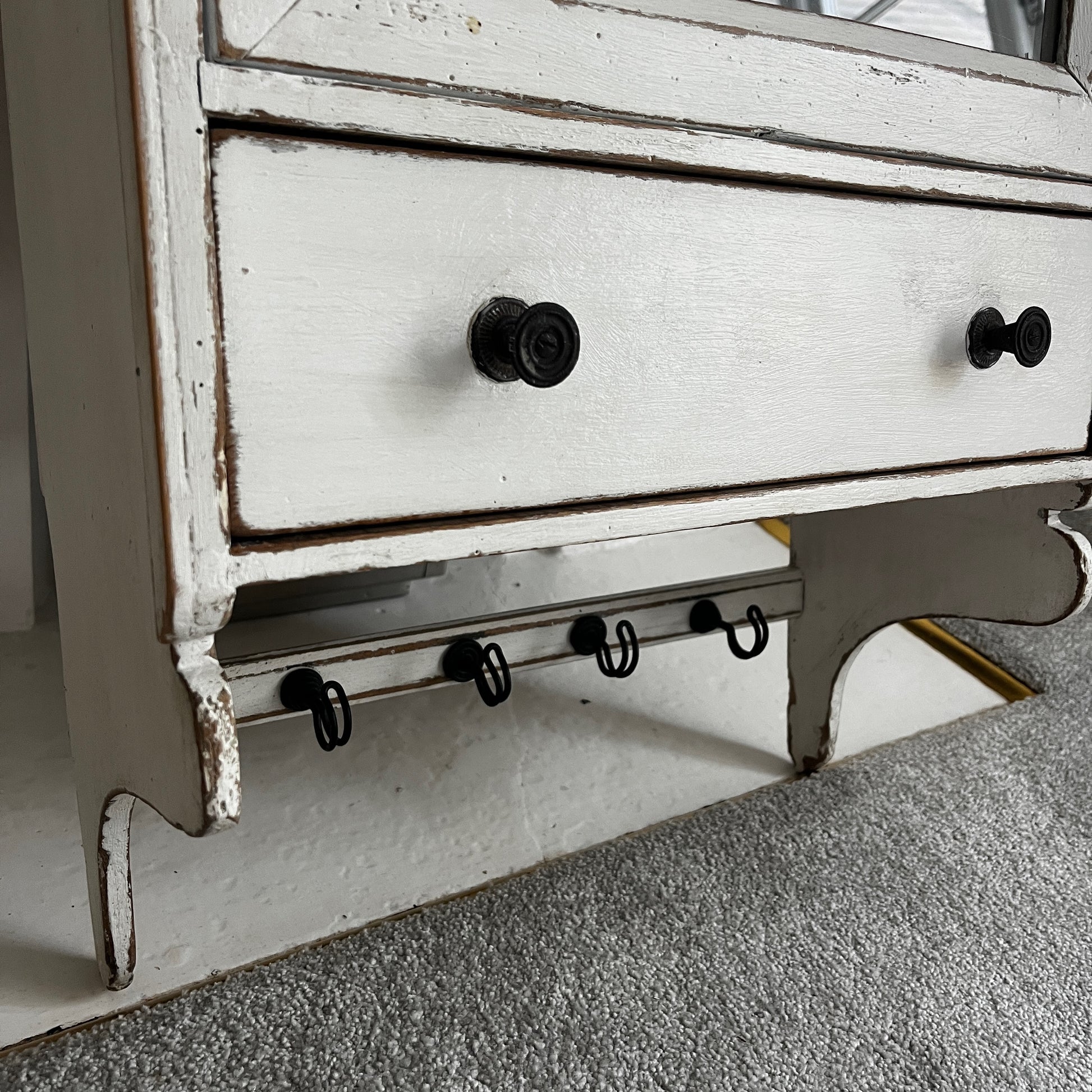 A French wall cupboard with a glazed glass door, two interior shelves, a single drawer, and practical hooks beneath. Its compact proportions and timeless rustic character make it ideal for use as a kitchen, bathroom, or hallway cabinet.