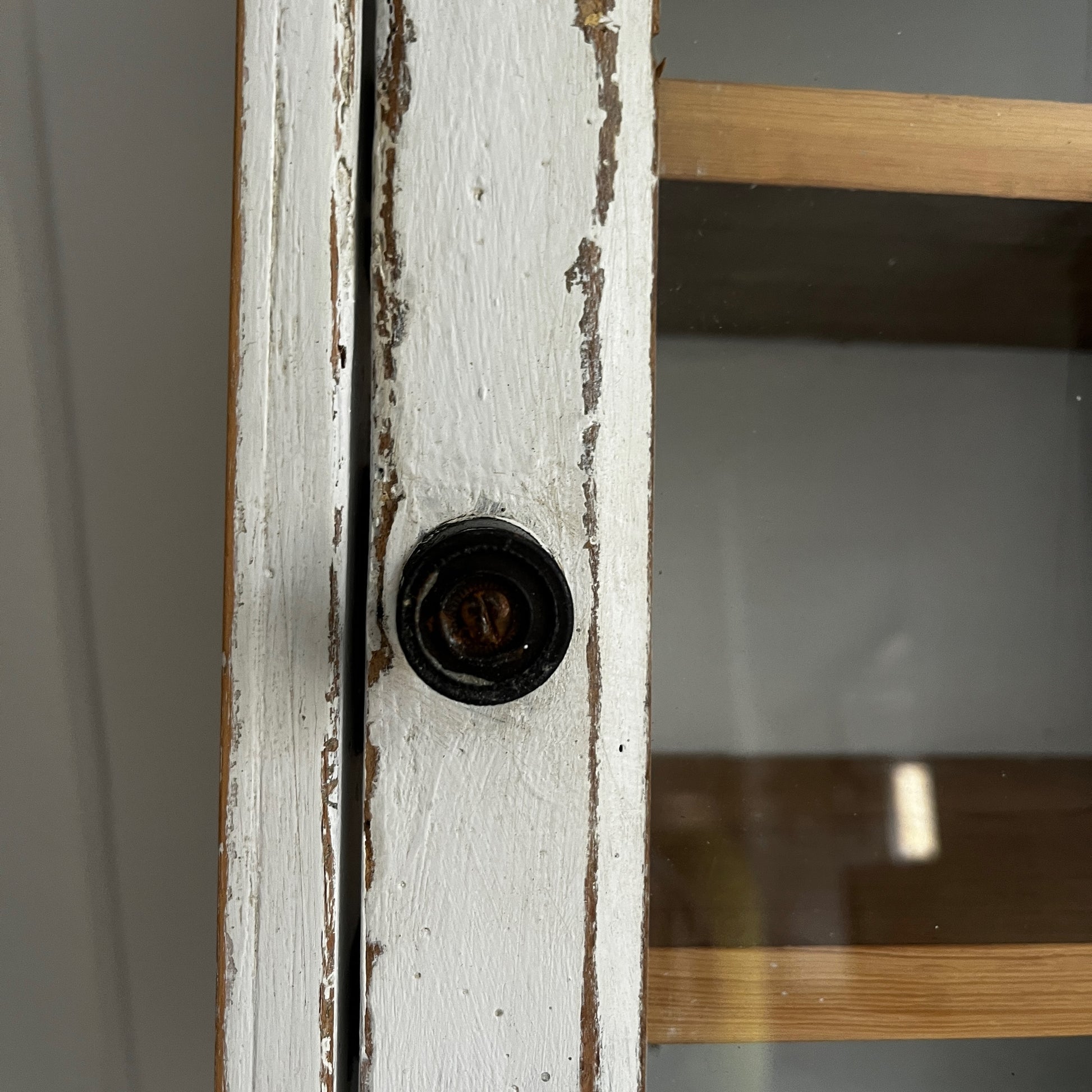 A French wall cupboard with a glazed glass door, two interior shelves, a single drawer, and practical hooks beneath. Its compact proportions and timeless rustic character make it ideal for use as a kitchen, bathroom, or hallway cabinet.