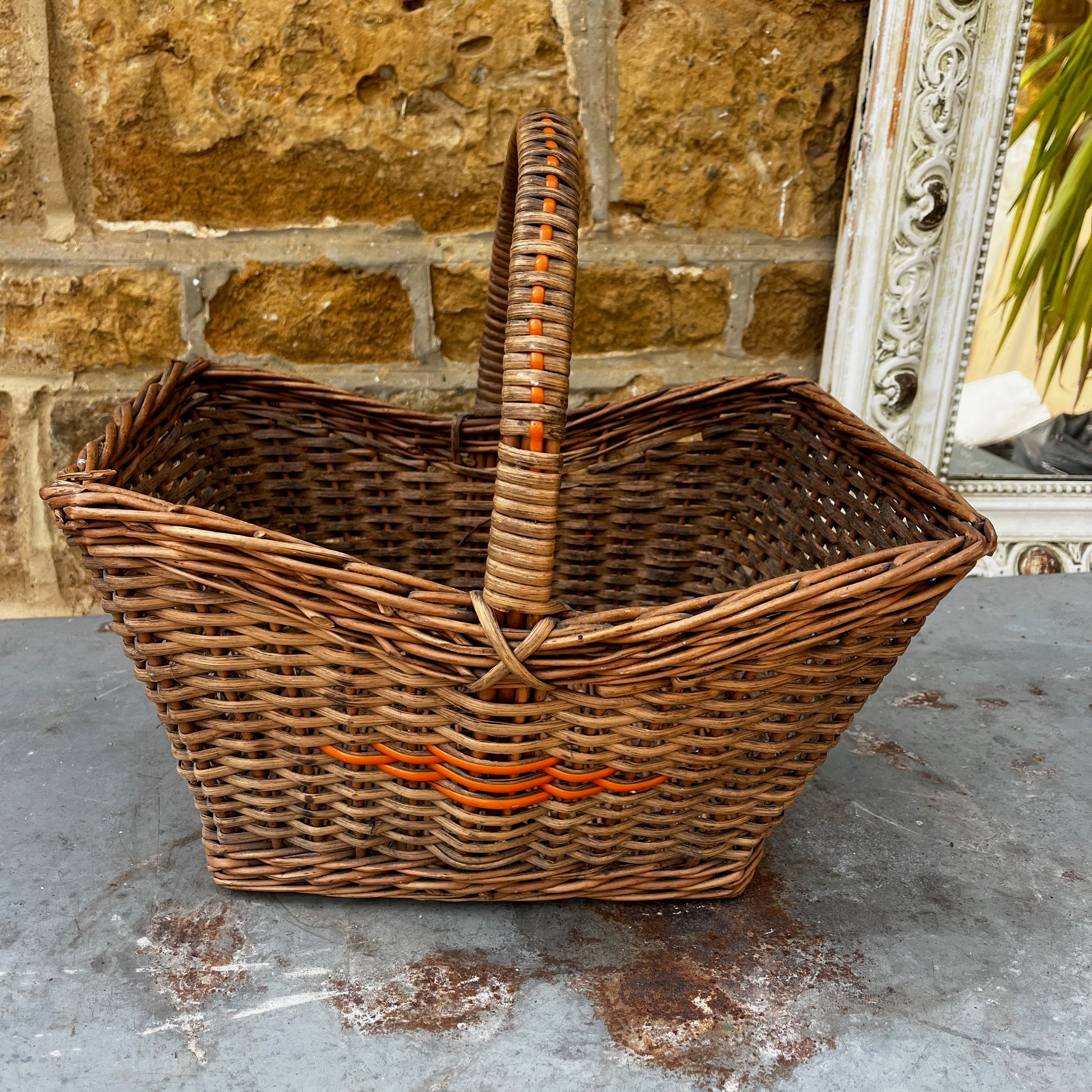 Vintage wicker basket with woven construction and orange detailing