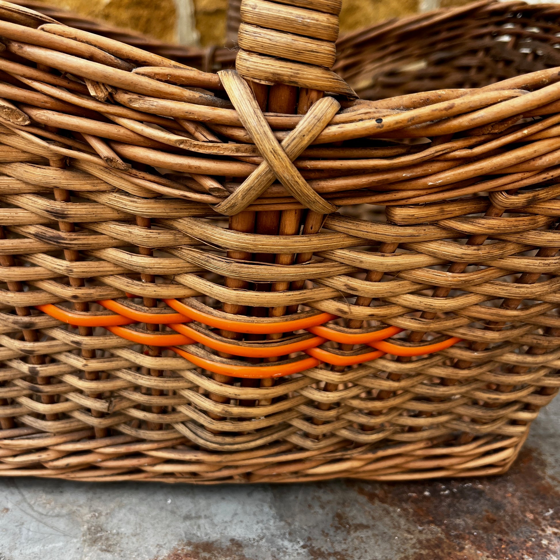 Vintage wicker basket with woven construction and orange detailing