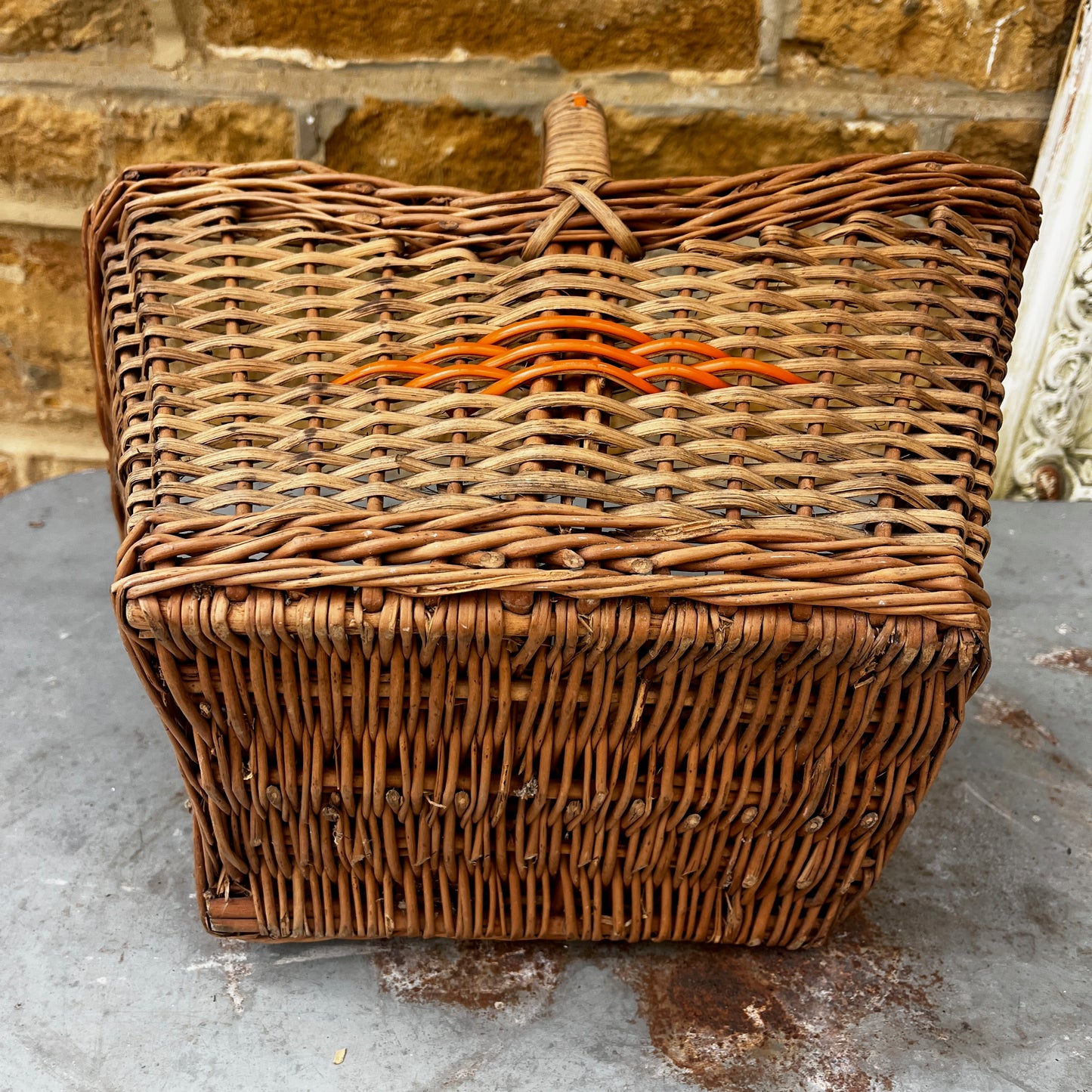 Vintage wicker basket with woven construction and orange detailing