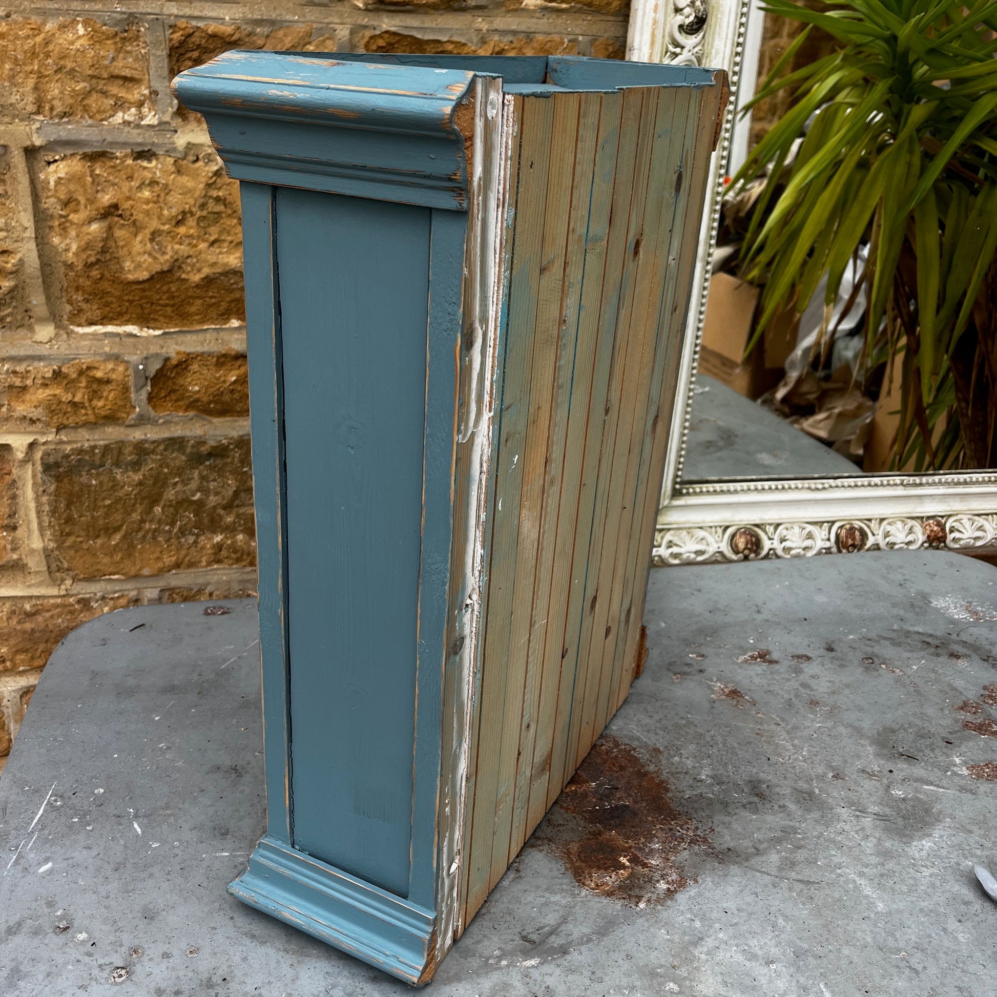 Vintage French wooden wall cupboard painted blue on the exterior and white inside, featuring a glass-front door that reveals internal shelves. The piece has a rustic, timeworn finish and classic country-style charm.