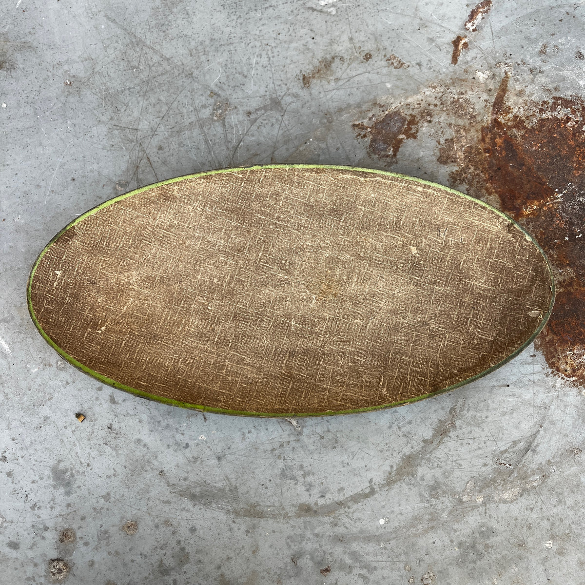 An oval vintage cardboard chocolate box with a colorful floral pattern.