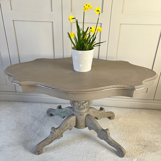 A classically elegant French vintage grey 'violin' shaped coffee table which has a central stem and four legs