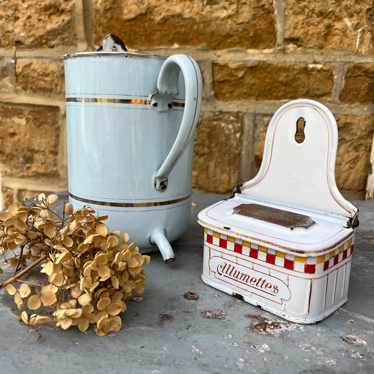 A vintage enamel allumettes box with a white background and red & yellow hand-painted geometric pattern, featuring a chippy weathered finish. The small, rectangular box has a hinged lid, exuding classic French charm