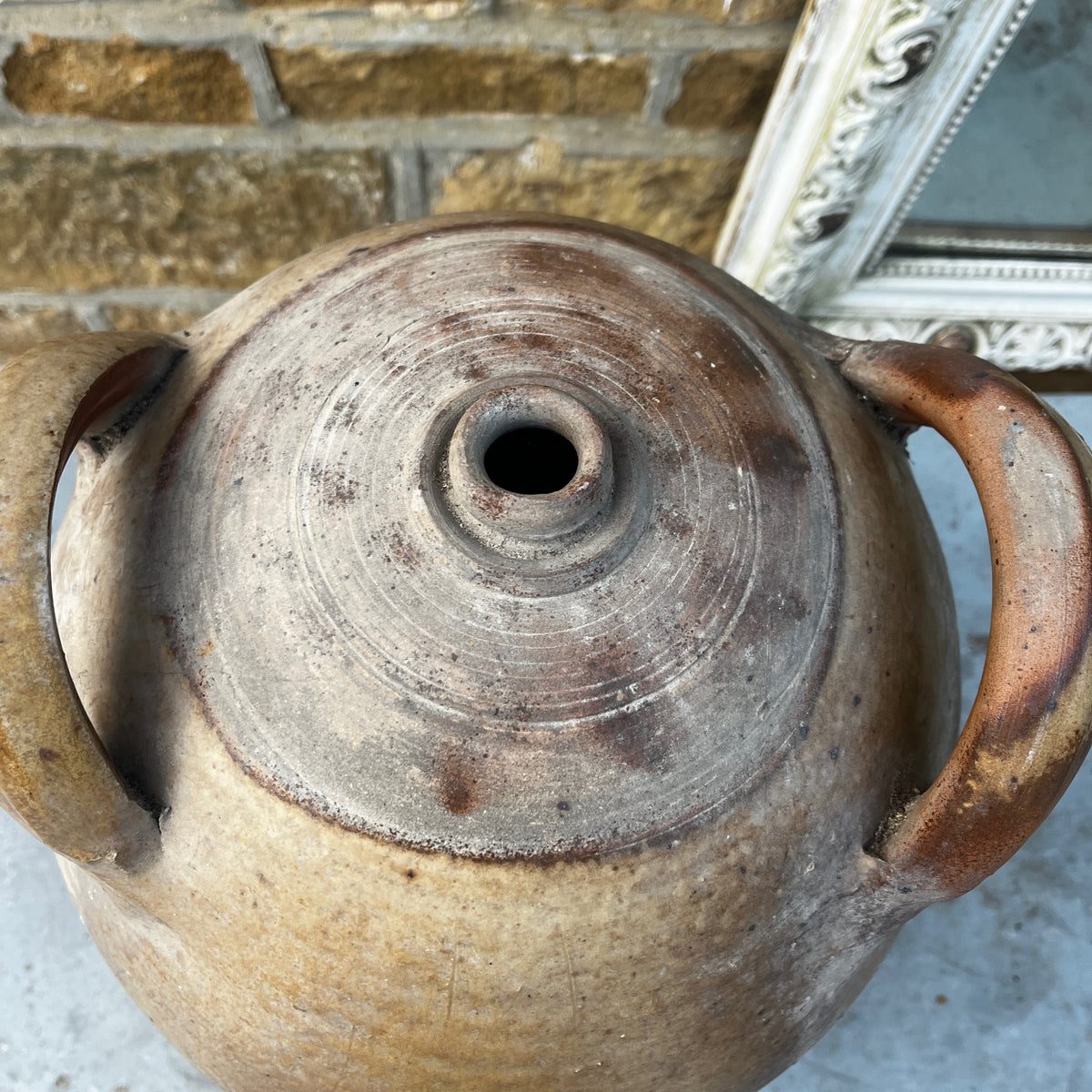 A large handmade ceramic amphora-style vase with a lid, featuring a rustic earthy brown and beige glaze
