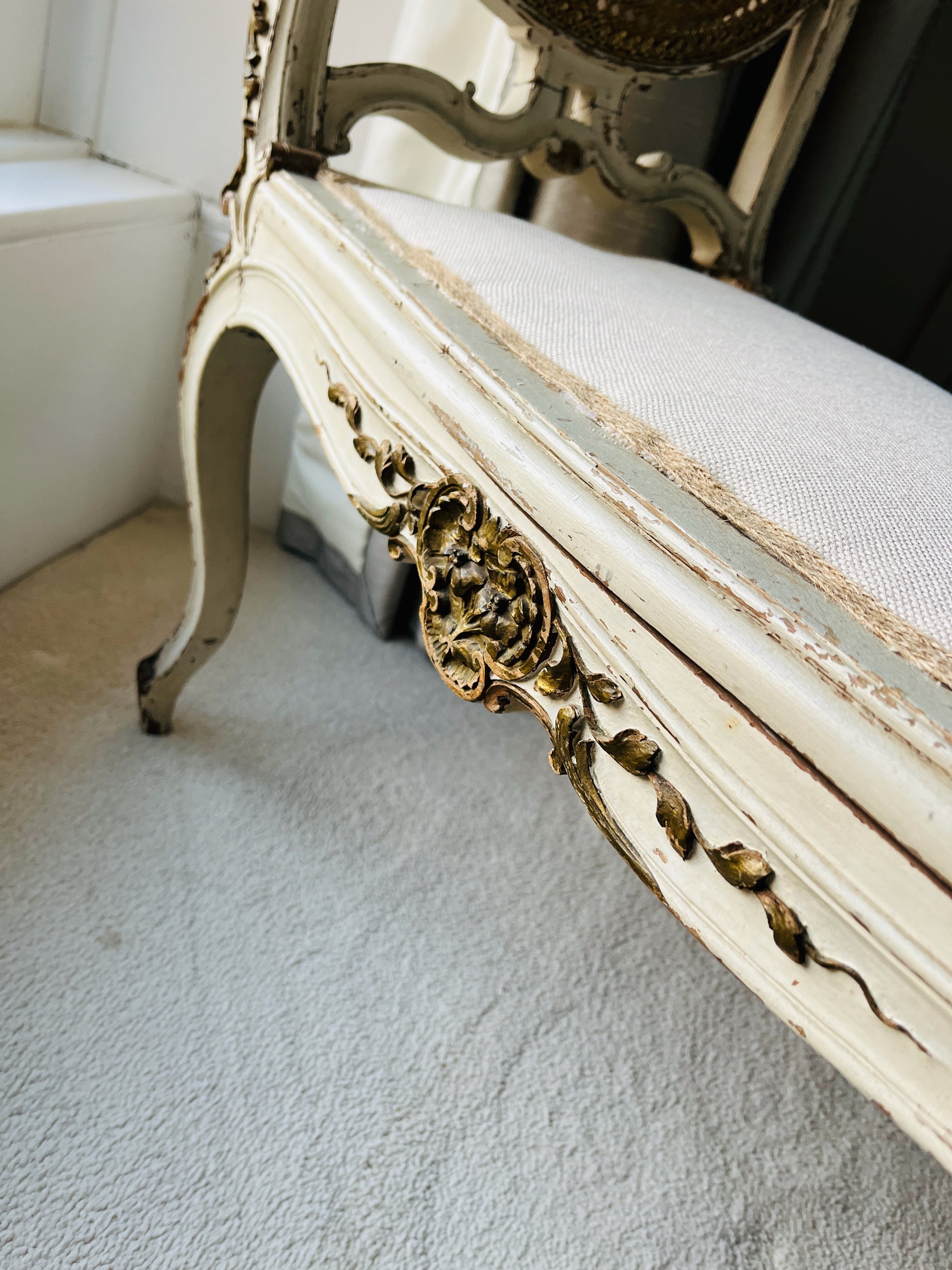 Antique French window seat featuring elegant caned arms and a newly upholstered seat, combining classic craftsmanship with timeless sophistication
