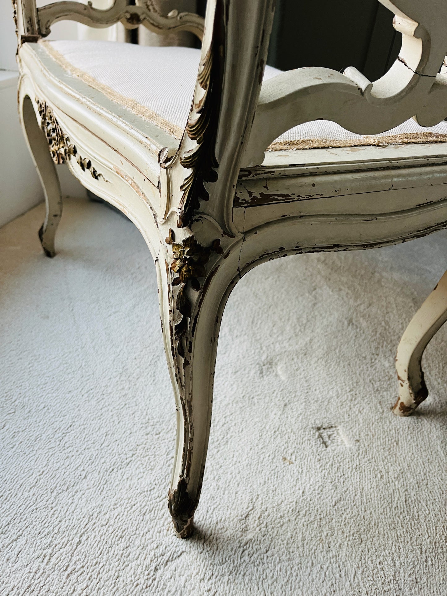 Antique French window seat featuring elegant caned arms and a newly upholstered seat, combining classic craftsmanship with timeless sophistication
