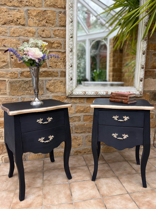 Pair of Louis Philippe-style bedside tables painted in matt black, adorned with gold painted handles and elegant gold detailing around the top, exuding luxury and classic sophistication