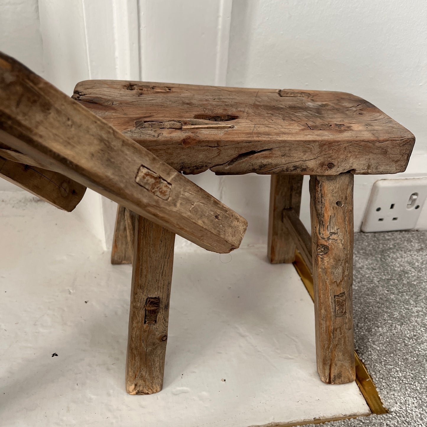 Rustic milking stools with a weathered finish, showcasing simple, sturdy design and vintage countryside charm, perfect for cozy, farmhouse-style decor