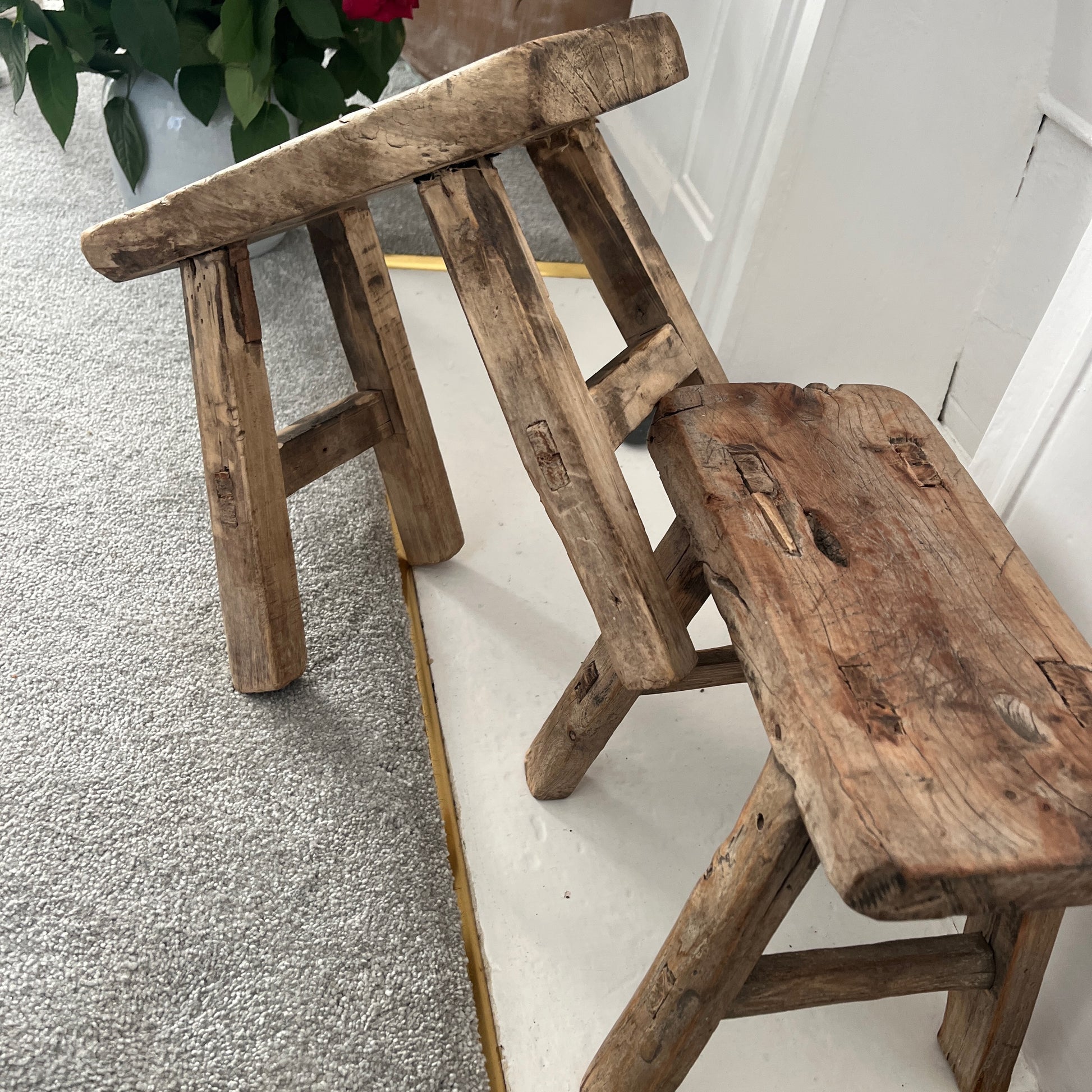 Rustic milking stools with a weathered finish, showcasing simple, sturdy design and vintage countryside charm, perfect for cozy, farmhouse-style decor