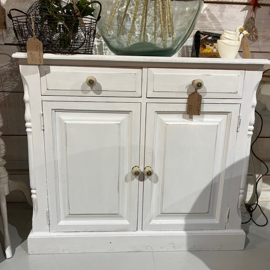 Vintage white pine cupboard with decorative detail on the top and down the sides.  Two drawers and two doors to the front with attractive knobs.