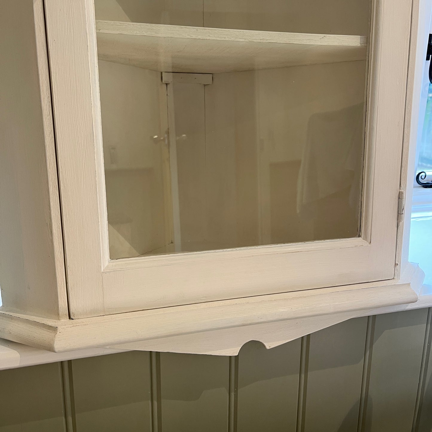A white wooden corner cabinet designed for bathroom use, which fits into a corner, with a single door and interior shelves for practical storage, offering a clean and classic look.