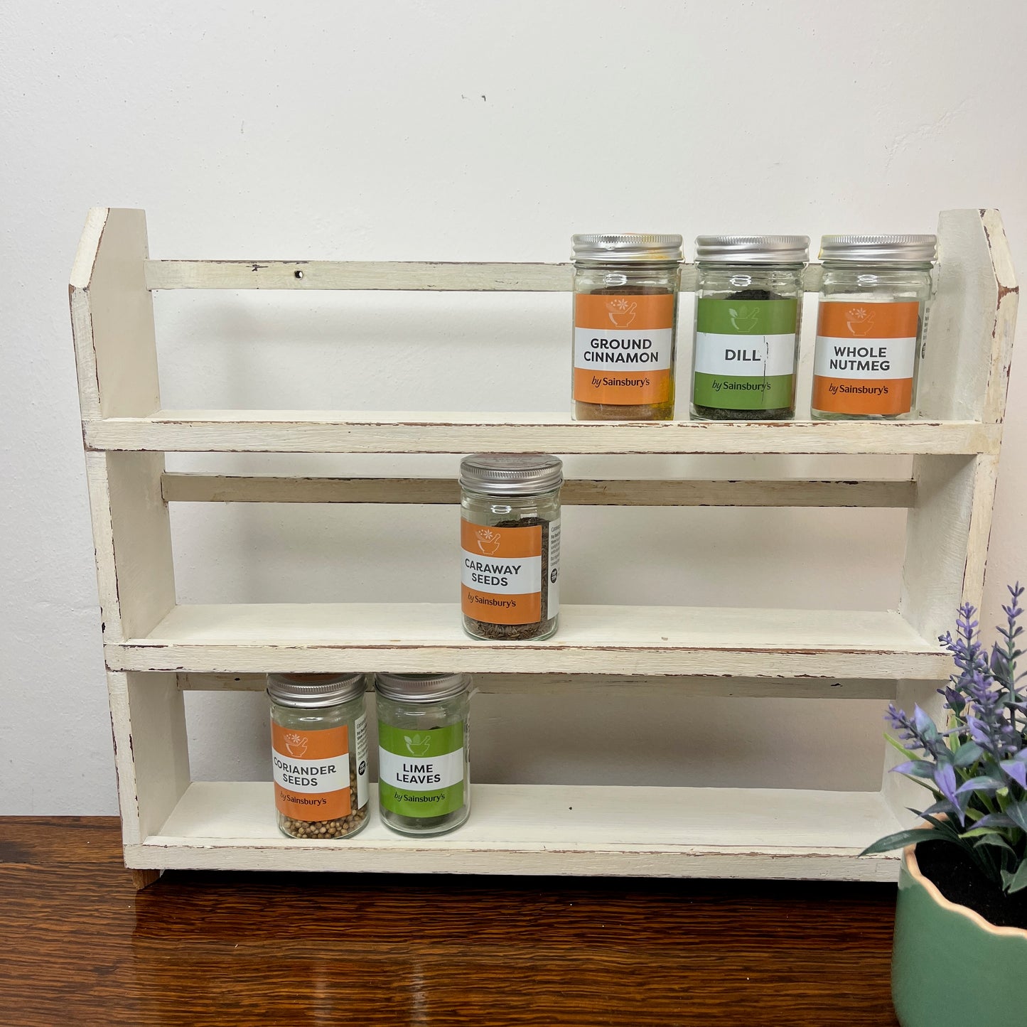 vintage white spice rack with 3 shelves which has become distressed over time